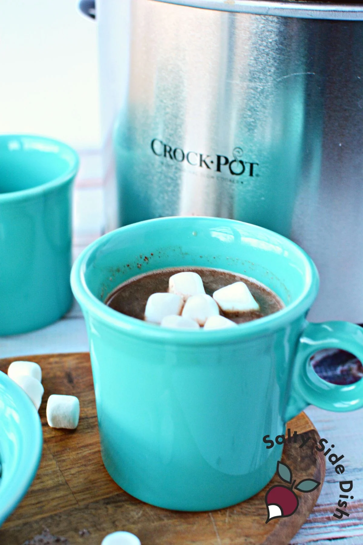 homemade hot chocolate with marshmallows sitting in a teal mug.