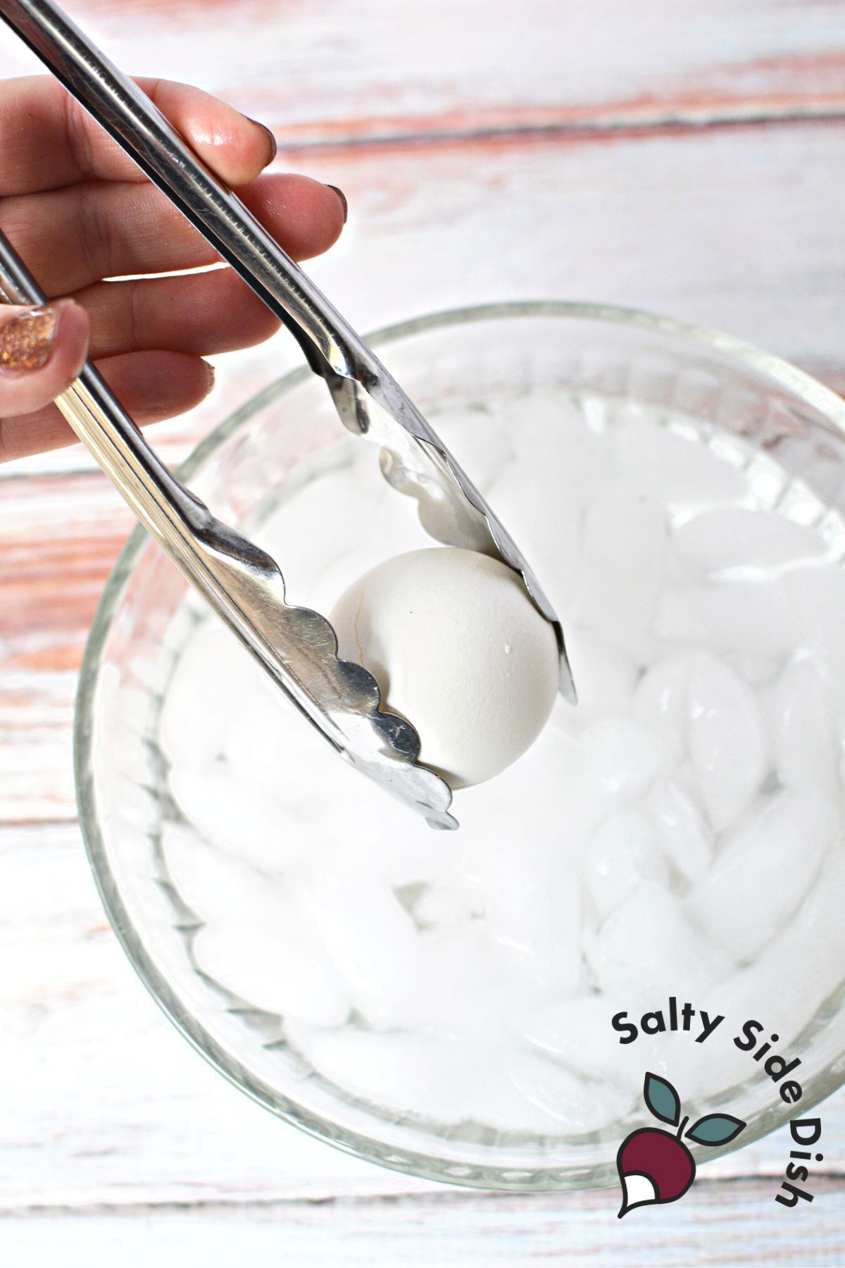 Placing the egg in the ice bath for cooling.