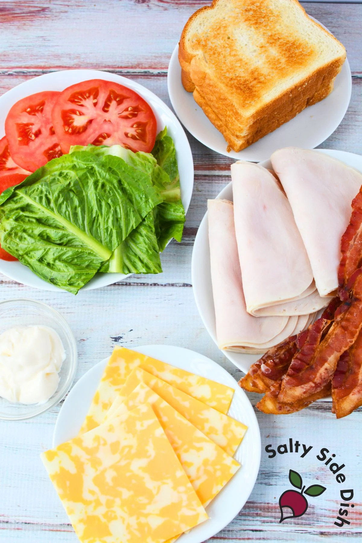 plates with all club sandwich ingredients spread out on them.