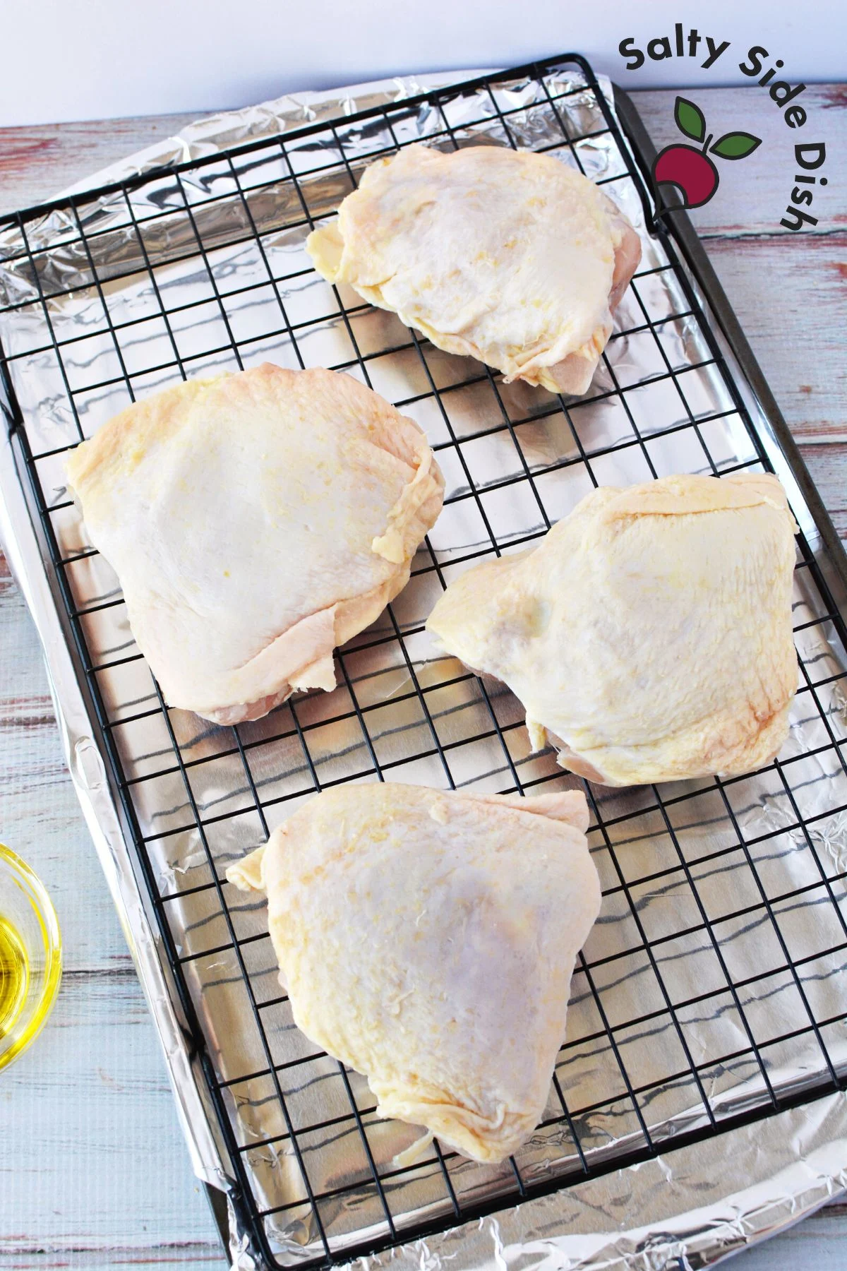 4 raw chicken thighs on a plate.