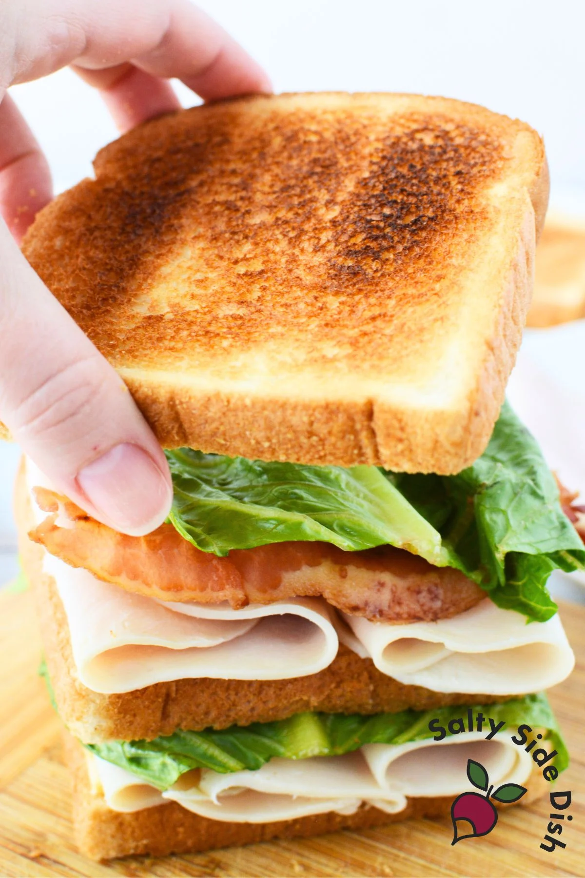 adding final layer of bread on a sandwich.