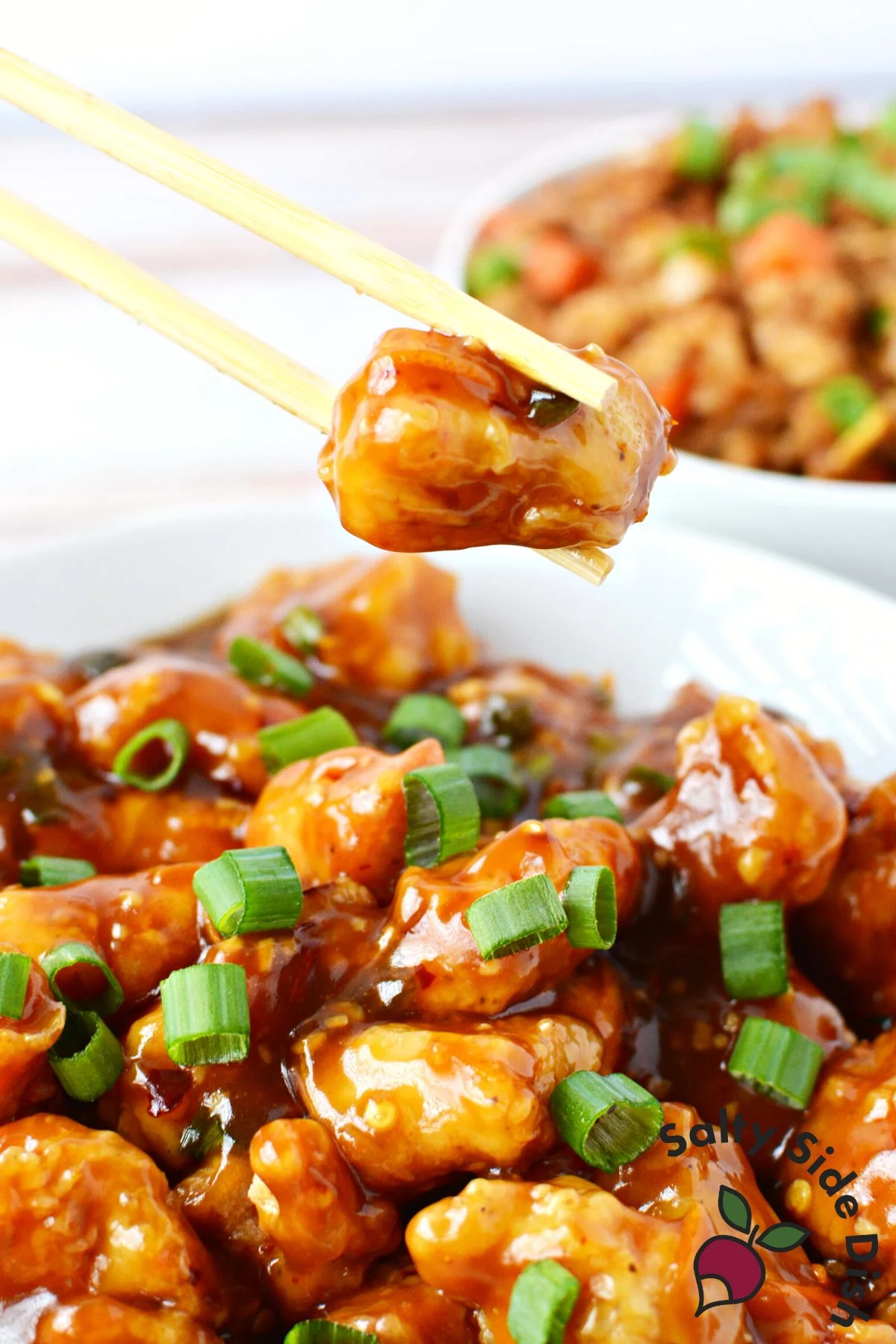 piece of chicken being held by a chopstick.