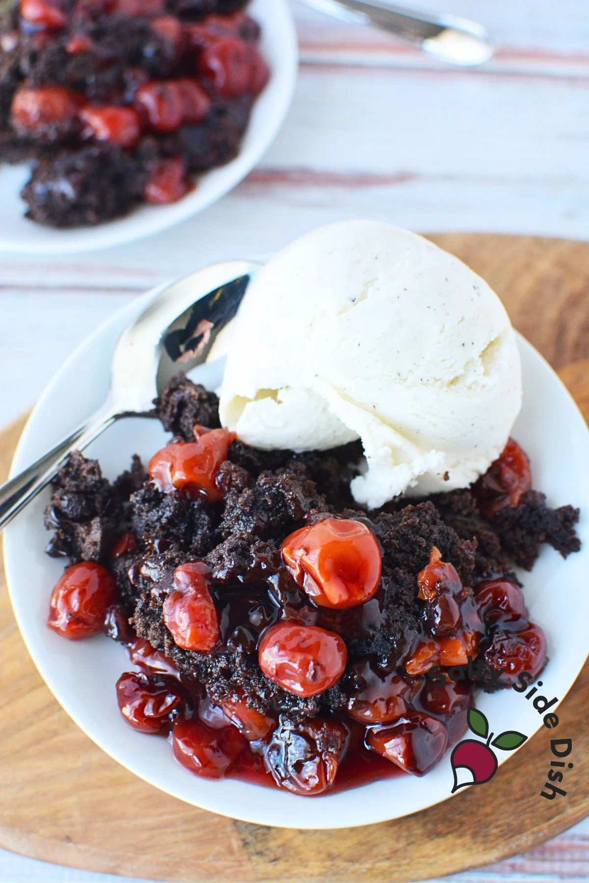 dump cake with ice cream on the side sitting on a serving plate.
