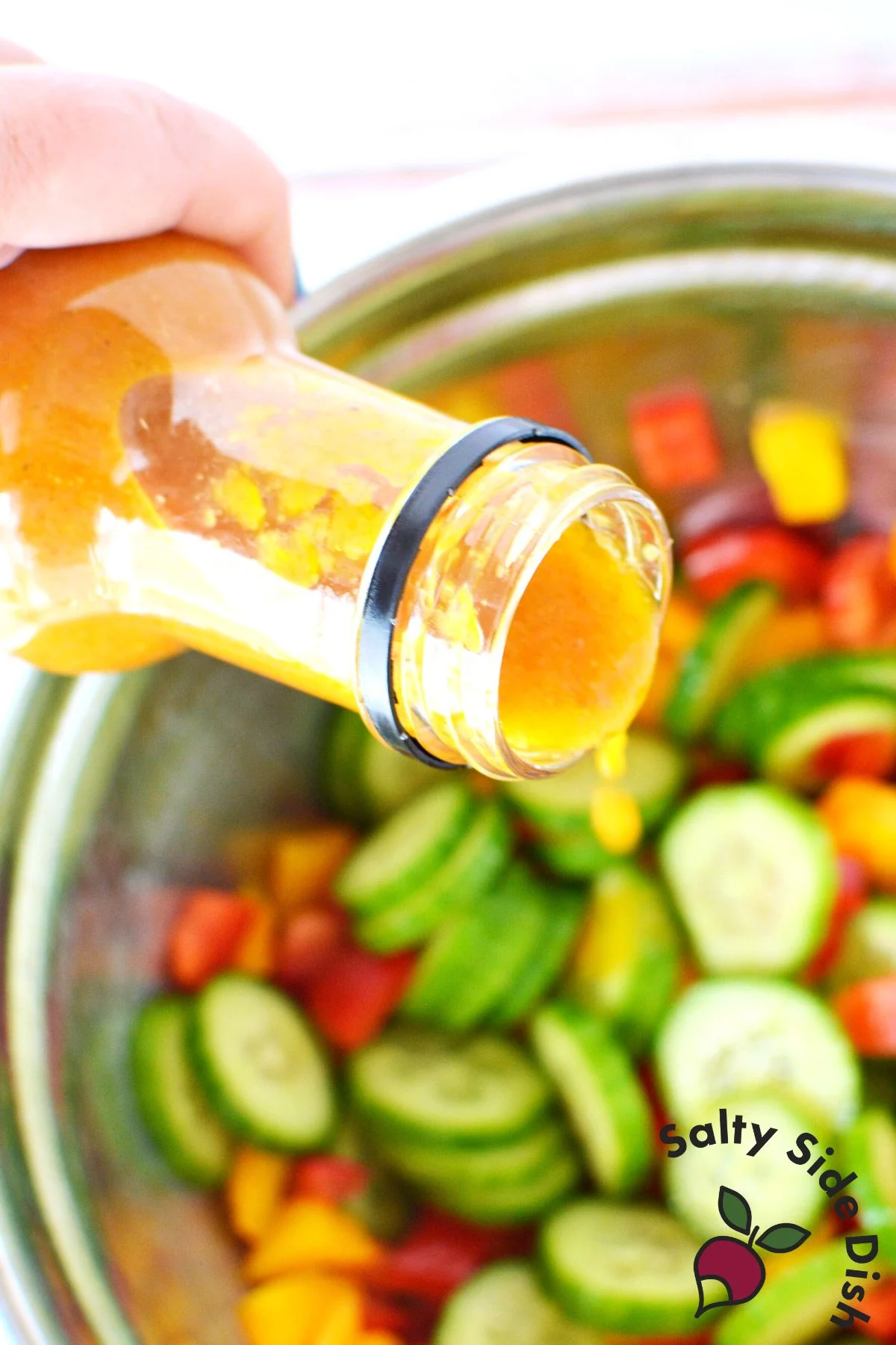 pouring ginger dressing on vegetables.
