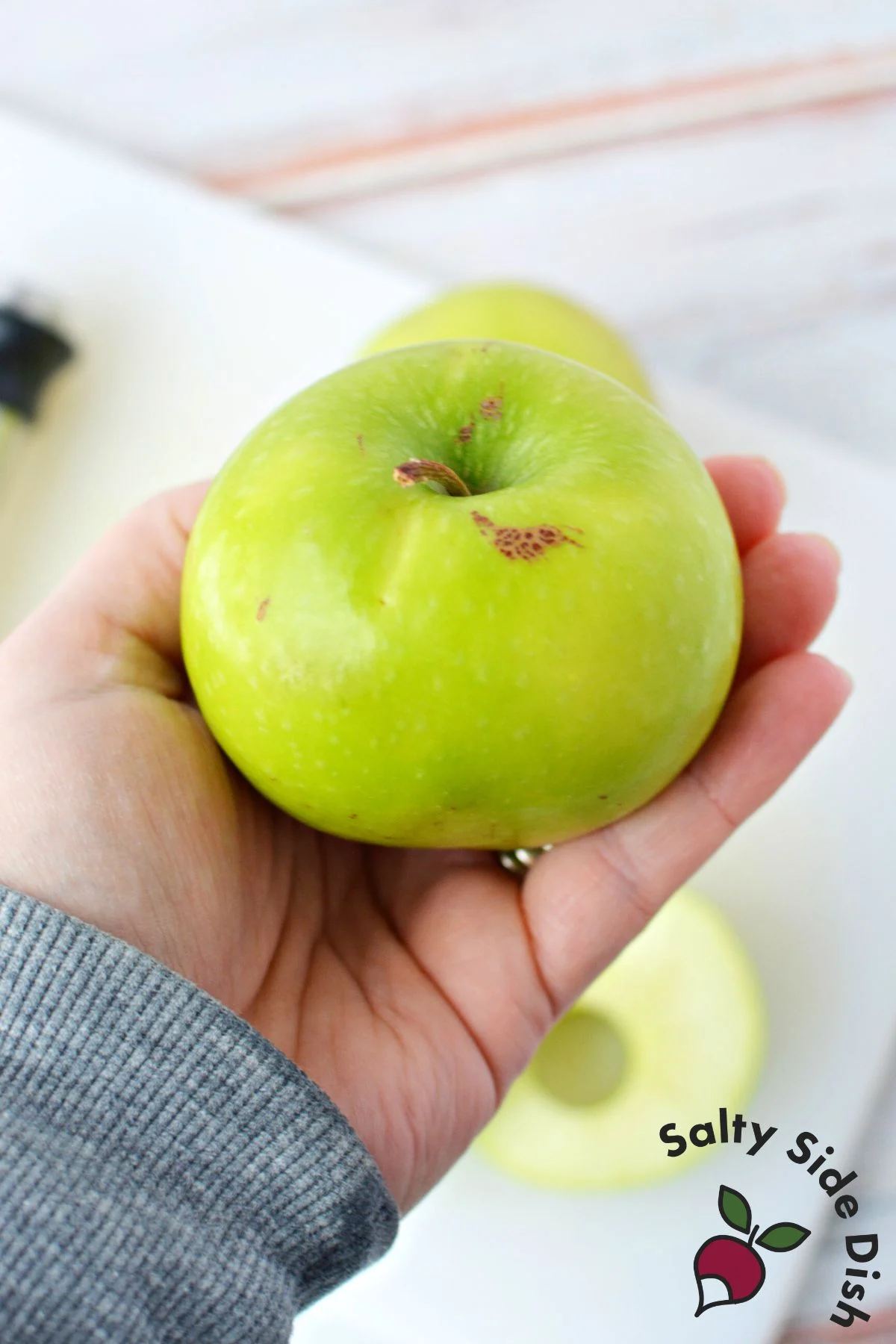 showing approximate size of green apple in relation to a hand.