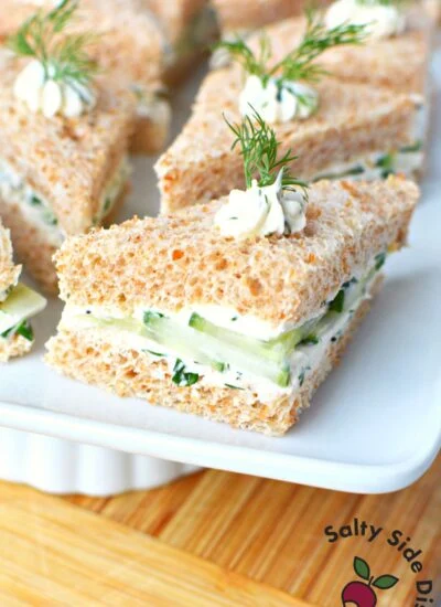 triangle cucumber sandwiches on a white plate.