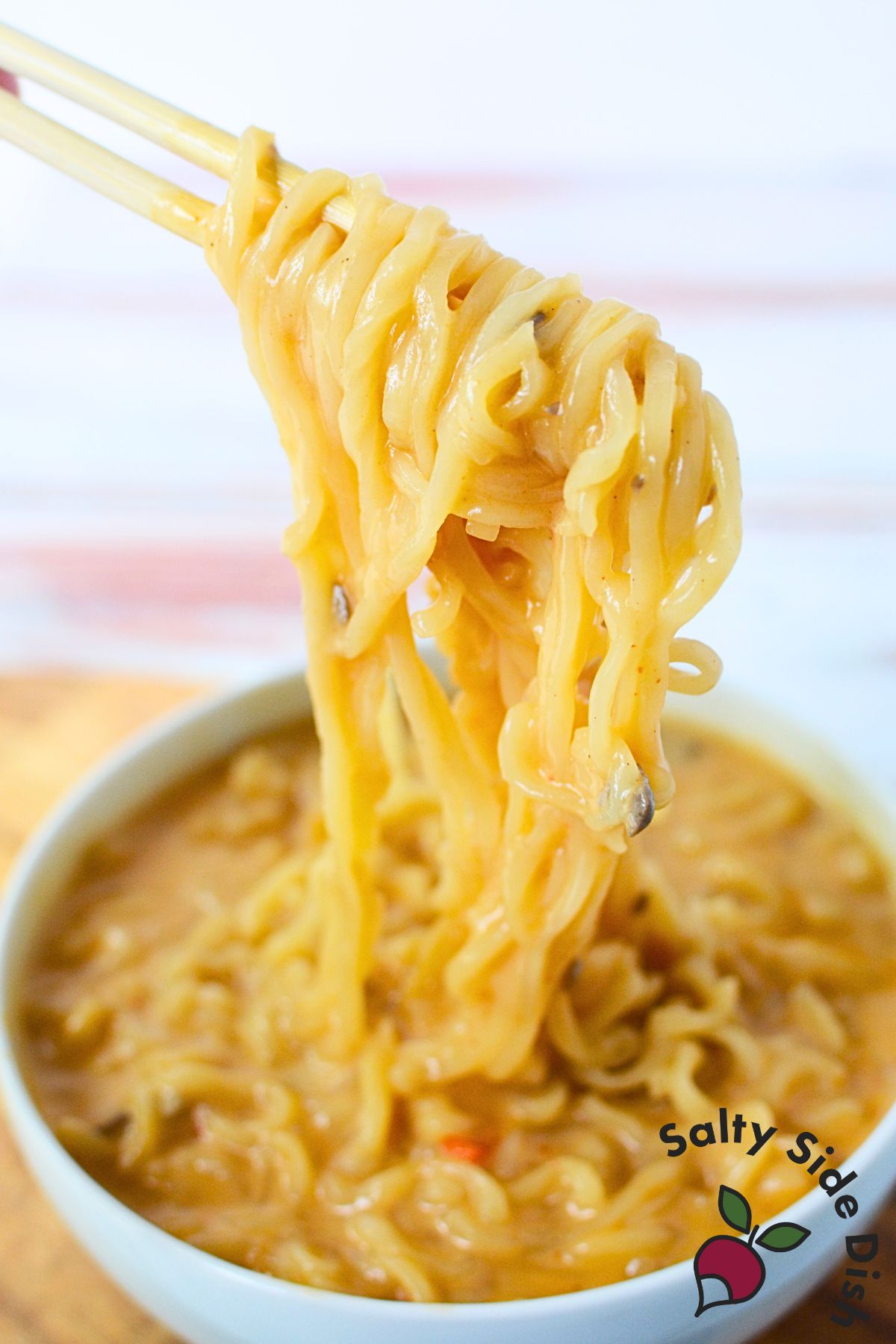 Shaq ramen noodles with chopsticks.