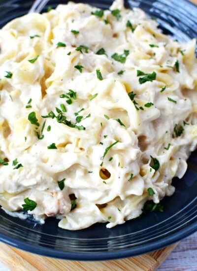 slow cooker chicken made with cream of chicken soup and cream cheese piled on a plate.