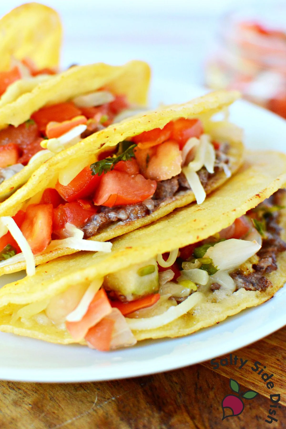plate of four fried tacos on a white plate.