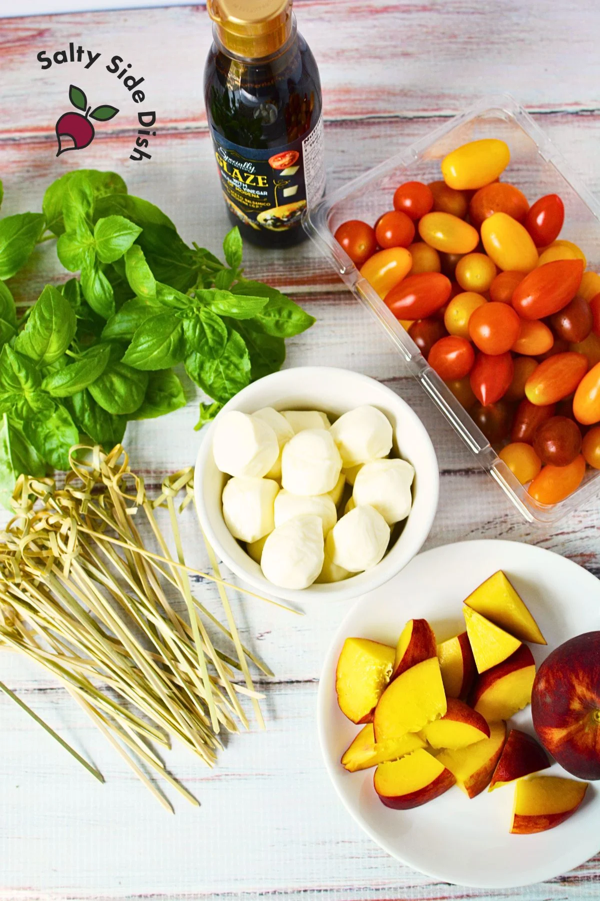 ingredients to make caprese skewers are all sitting on the counter.