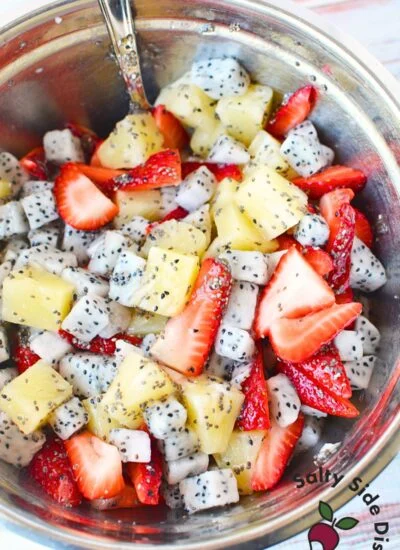 mixing dragon fruit salad in a bowl.
