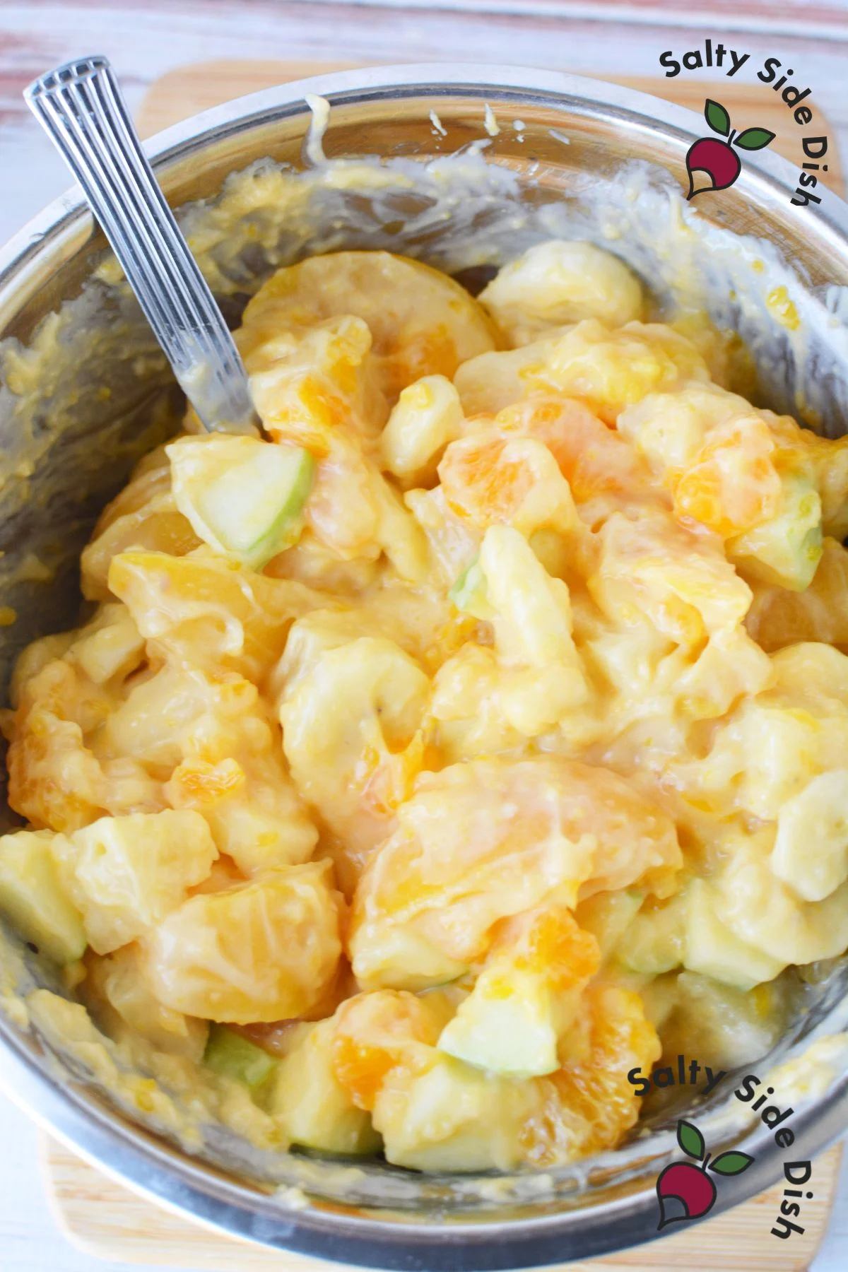 Close-up of creamy fruit salad with bananas and peaches.