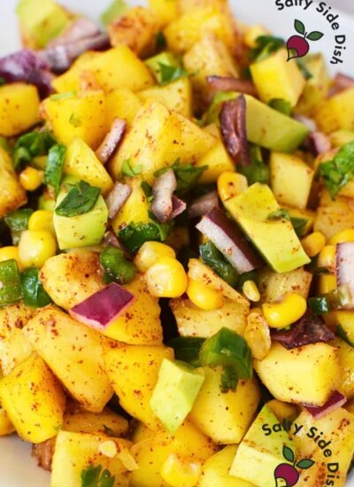 A vibrant bowl of Pineapple Mango Fruit Salad with fresh pineapple, mango, corn, red onion, jalapeno, and cilantro.