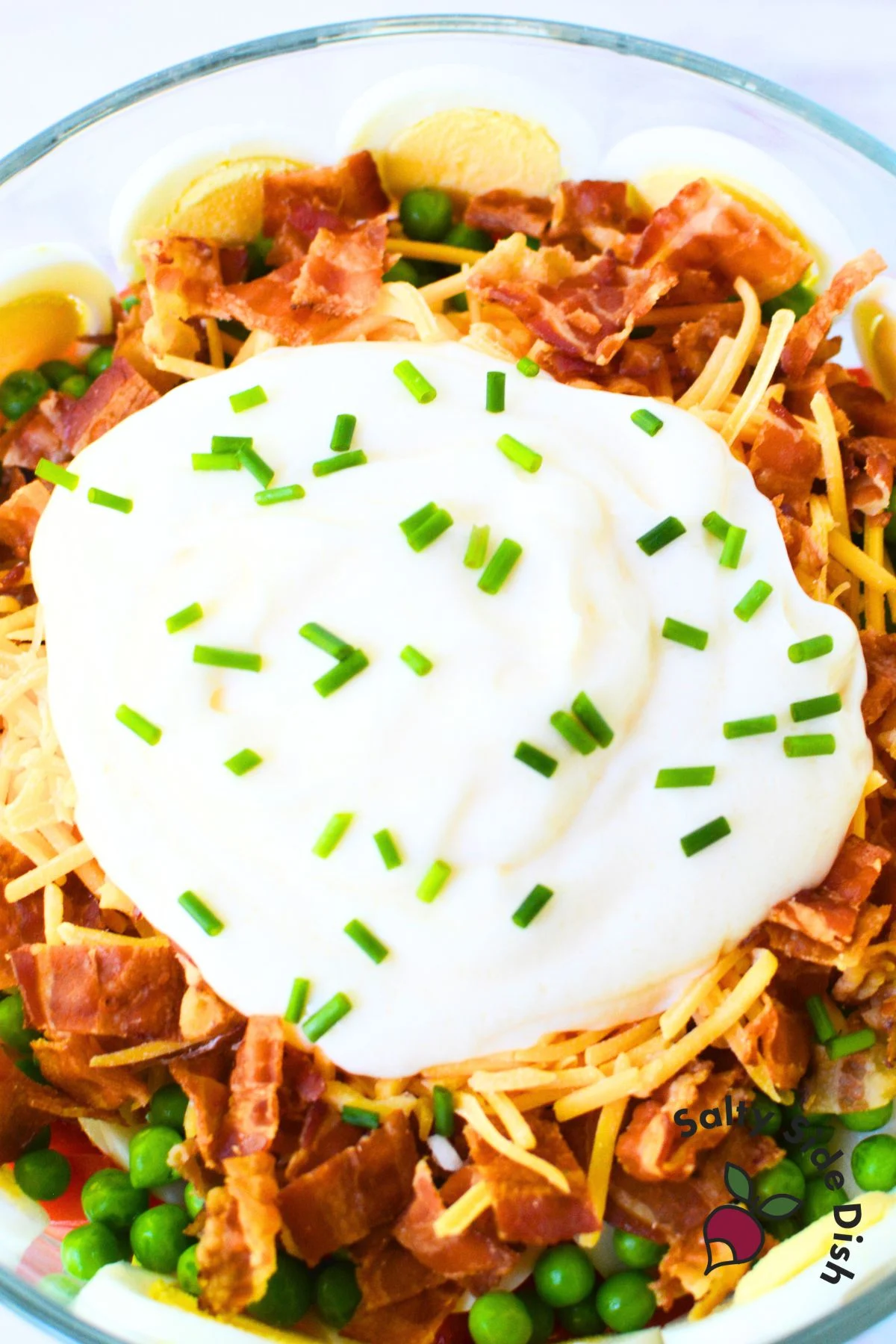 7 layer salad recipe in a trifle bowl.