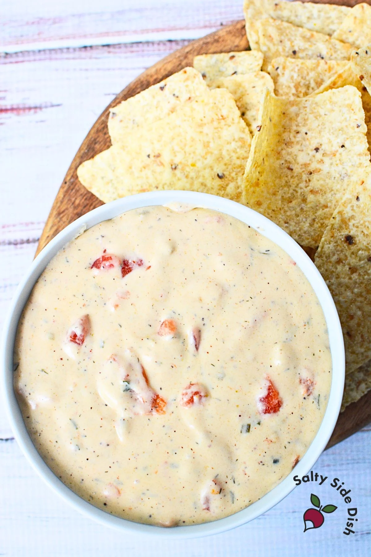 large bowl of queso with a side of chips.