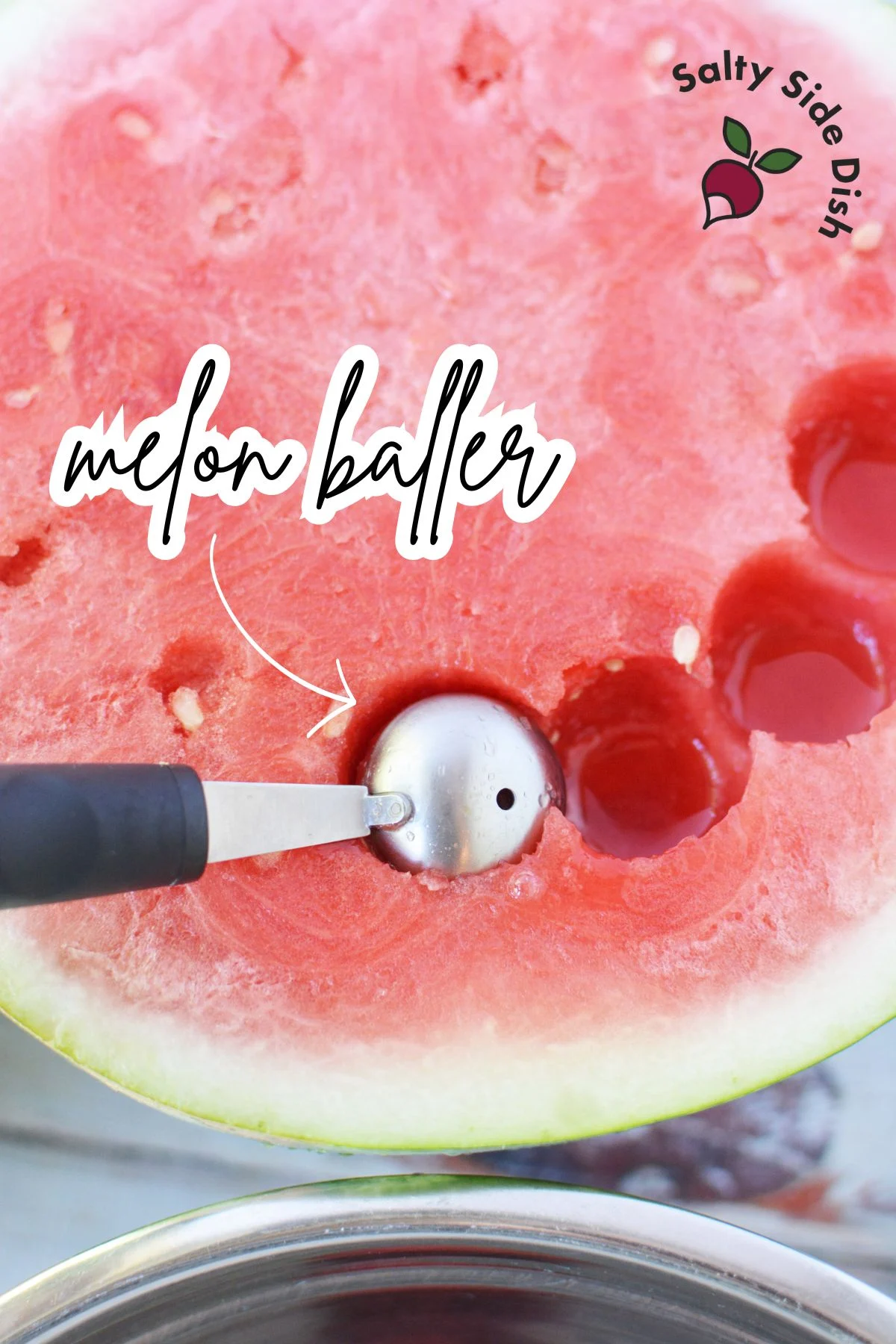 using a melon baller on a watermelon for a fruit salad recipe.