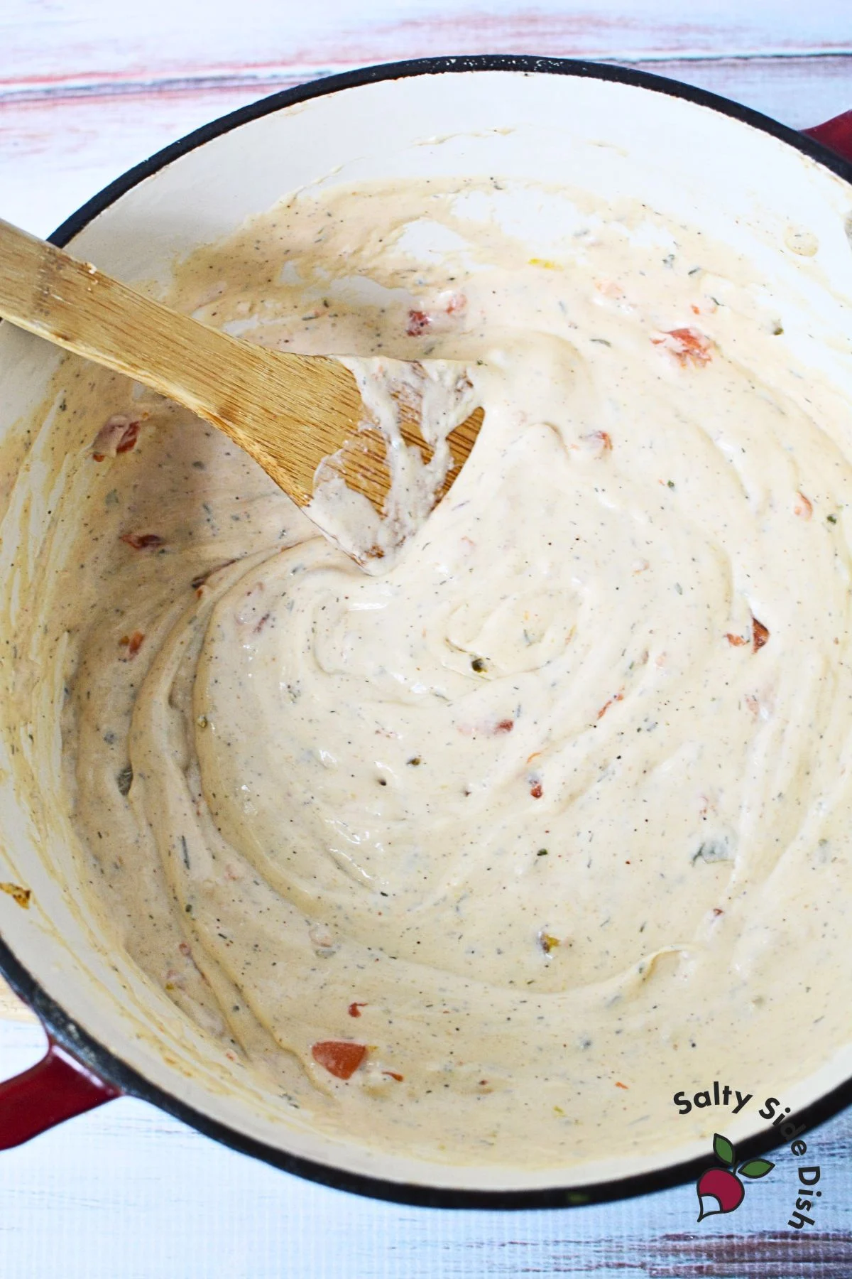 stirring ranch and queso in a stock pot.