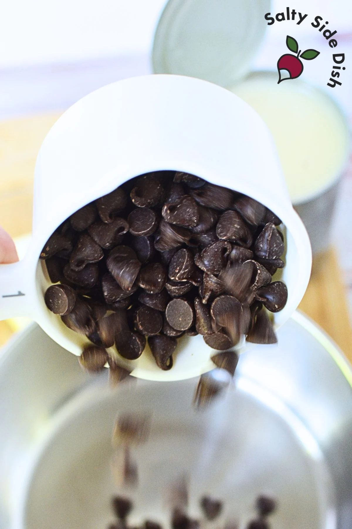 pouring chocolate chips into the saucepan.
