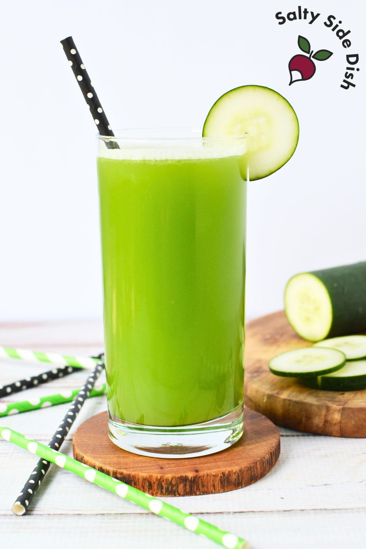 Freshly made cucumber juice in a glass with sliced cucumbers on the side..