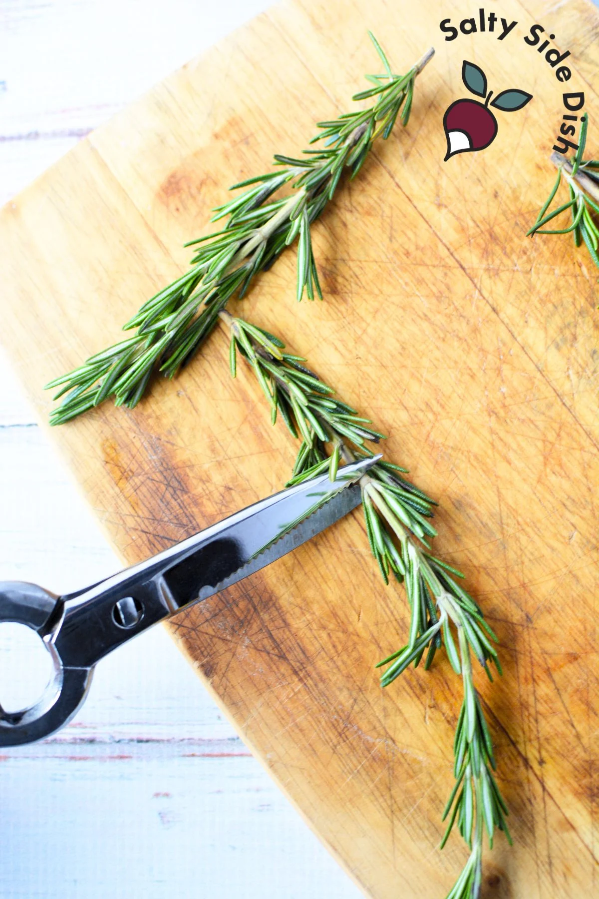 cutting a sprig of rosemary.