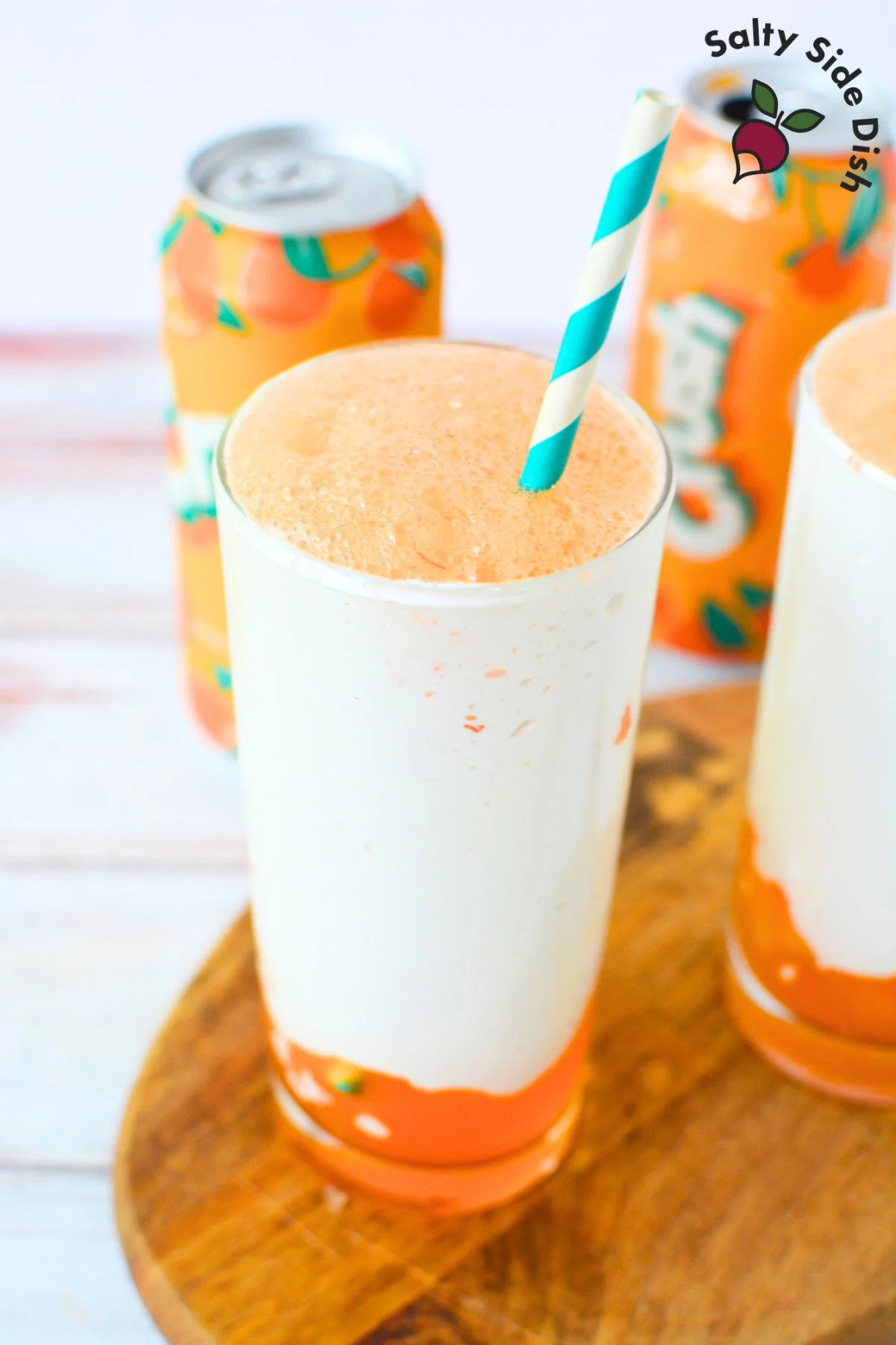 orange fluffy coke in a glass with a straw.