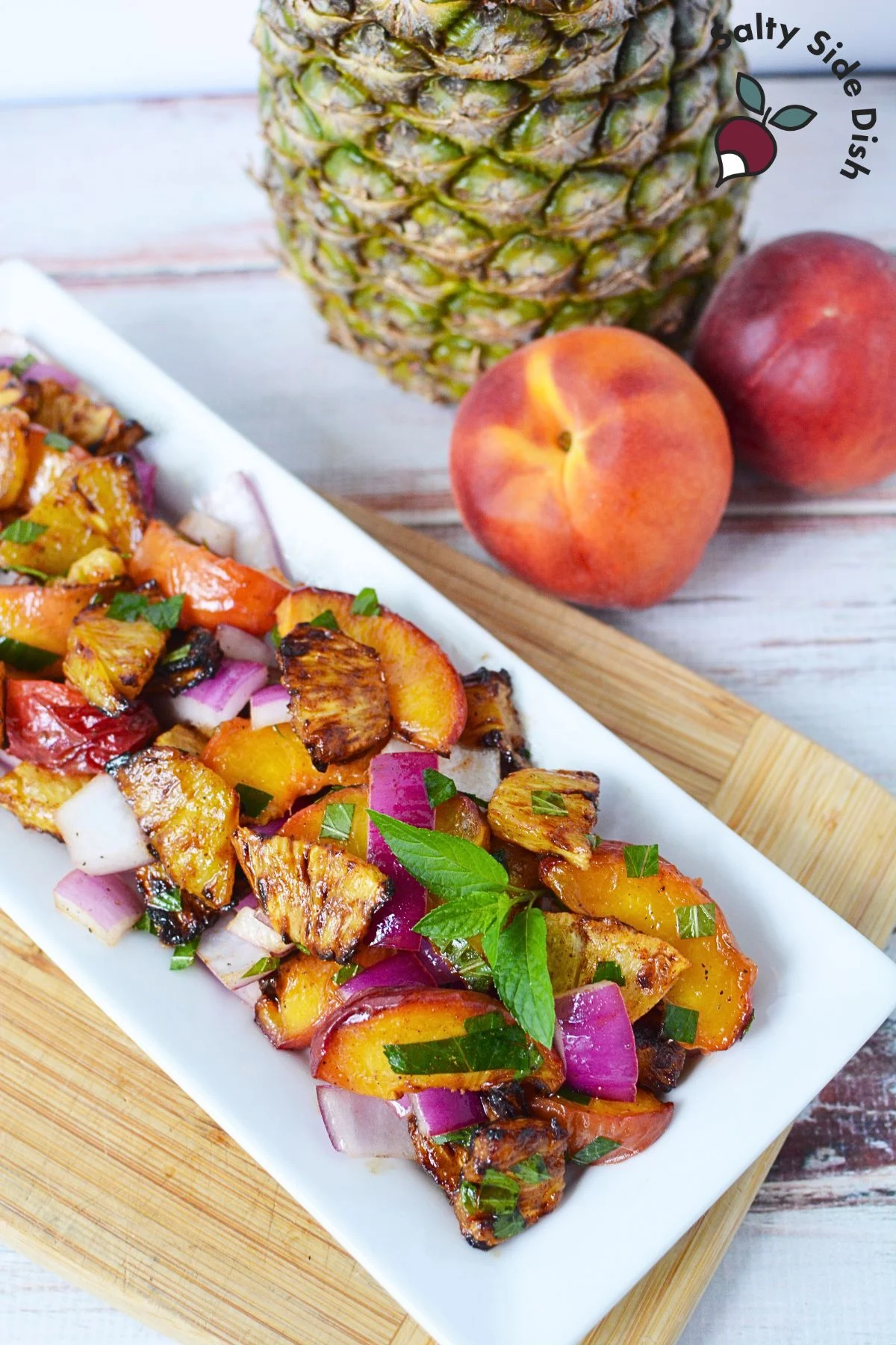 warm grilled pineapple salad on a white plate ready to serve.