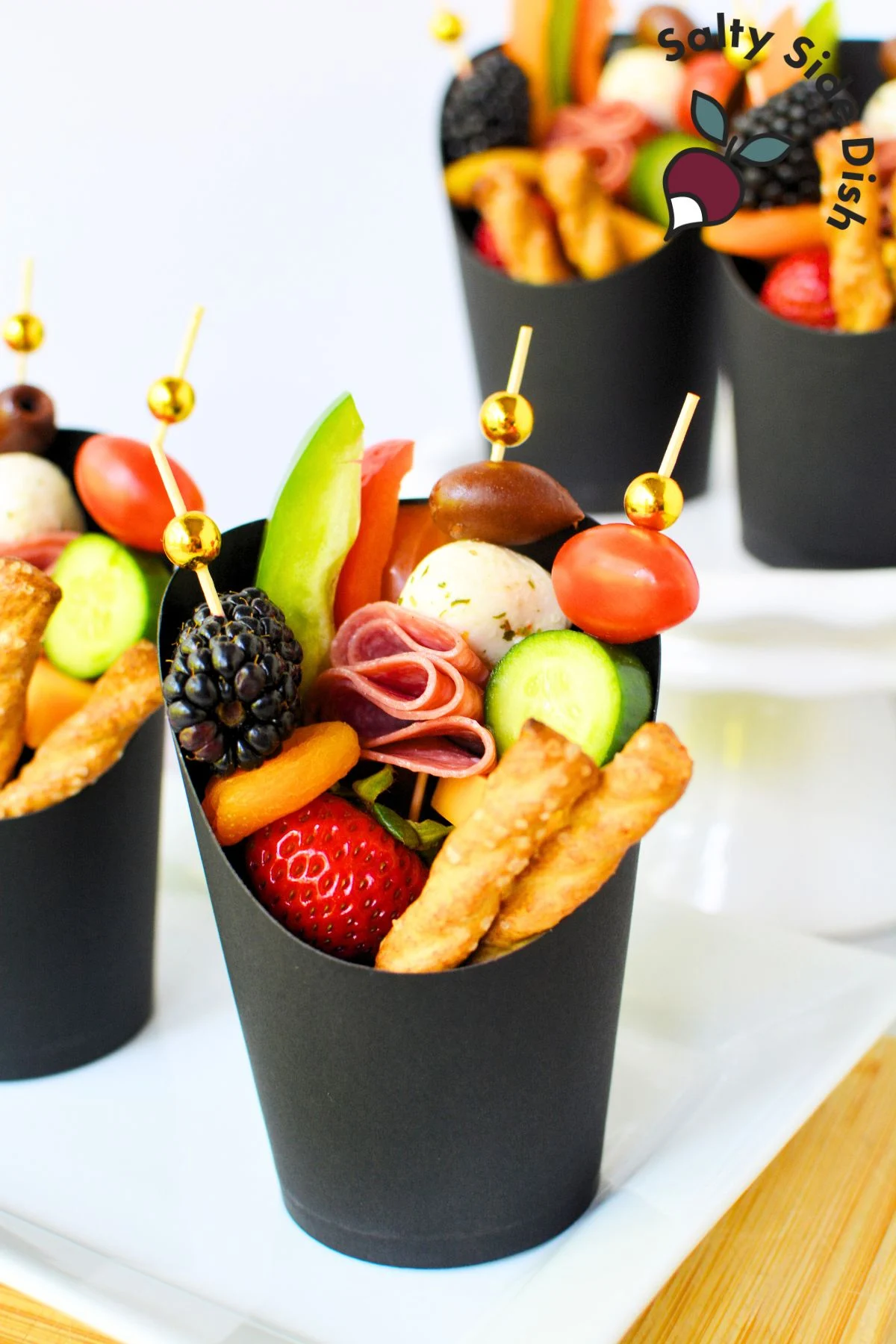 adding a variety of ingredients into a black paper cup.
