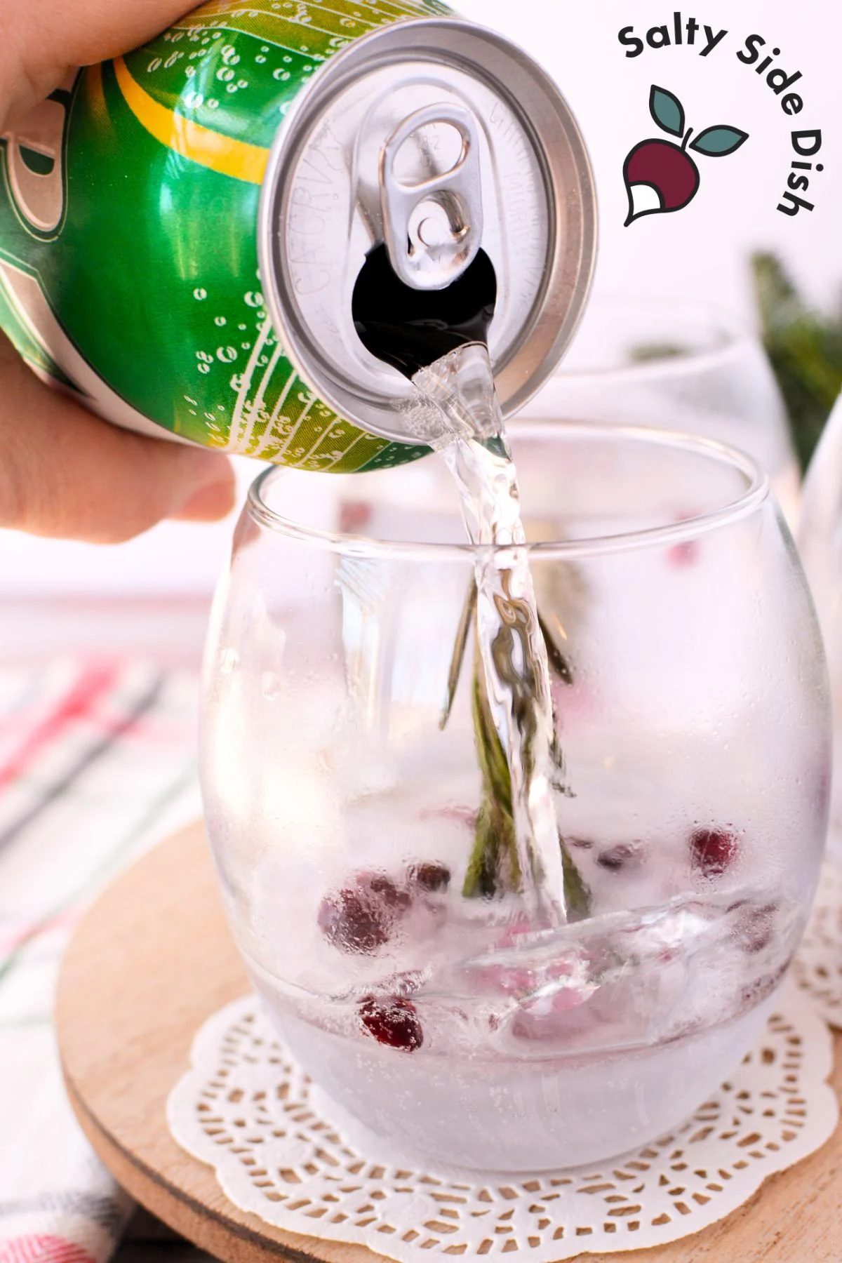 pouring a sprite in as a christmas cocktail.