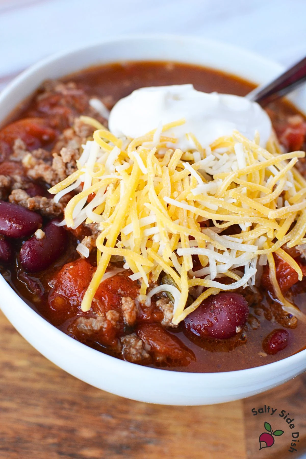 chili in a bowl with sour cream and cheese.