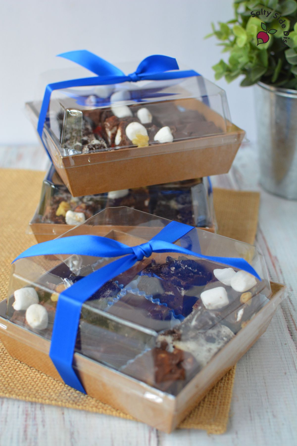 charcuterie boxes with clear lids tied with a bow.