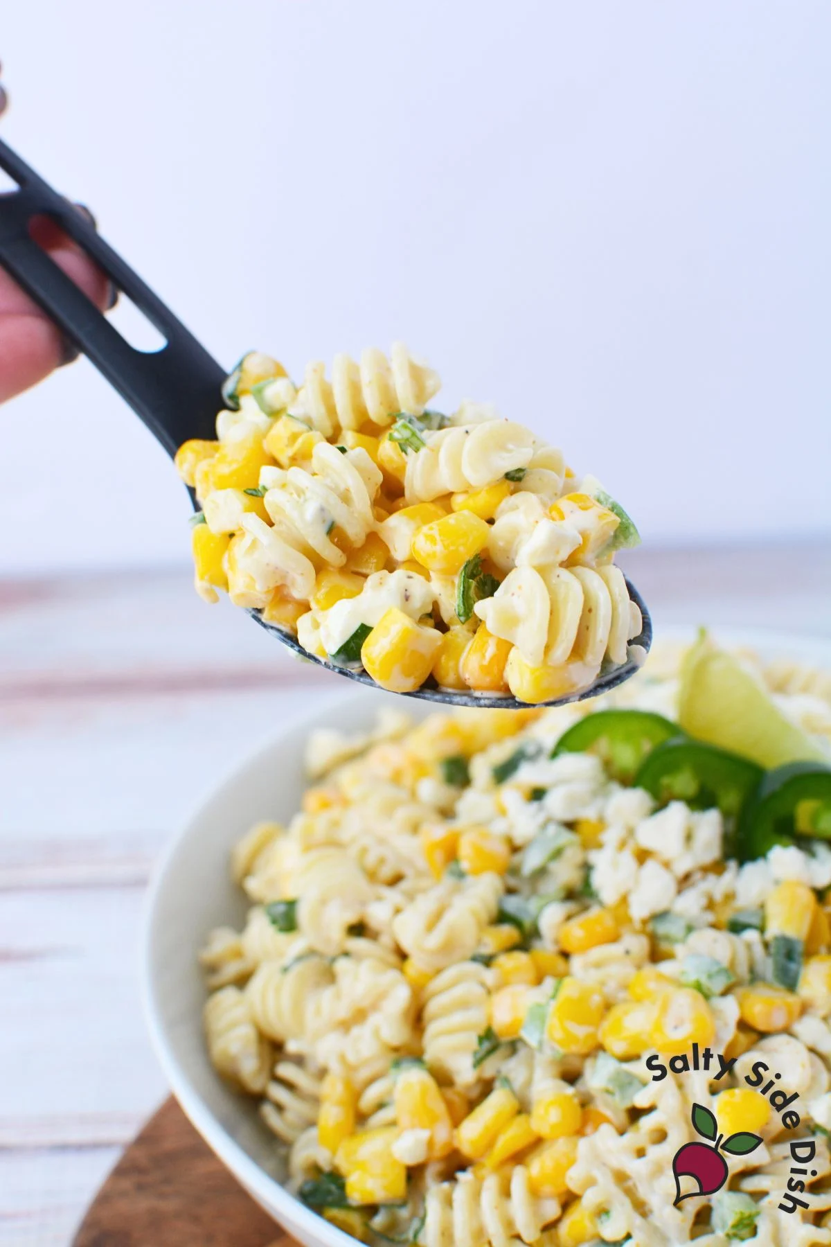 Mexican street corn pasta salad on a serving spoon.
