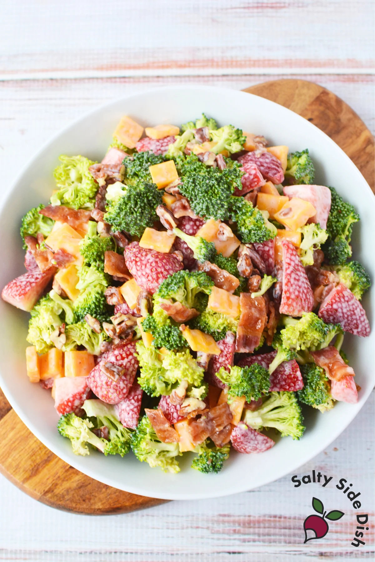 white bowl with potluck salad with strawberry broccoli salad.
