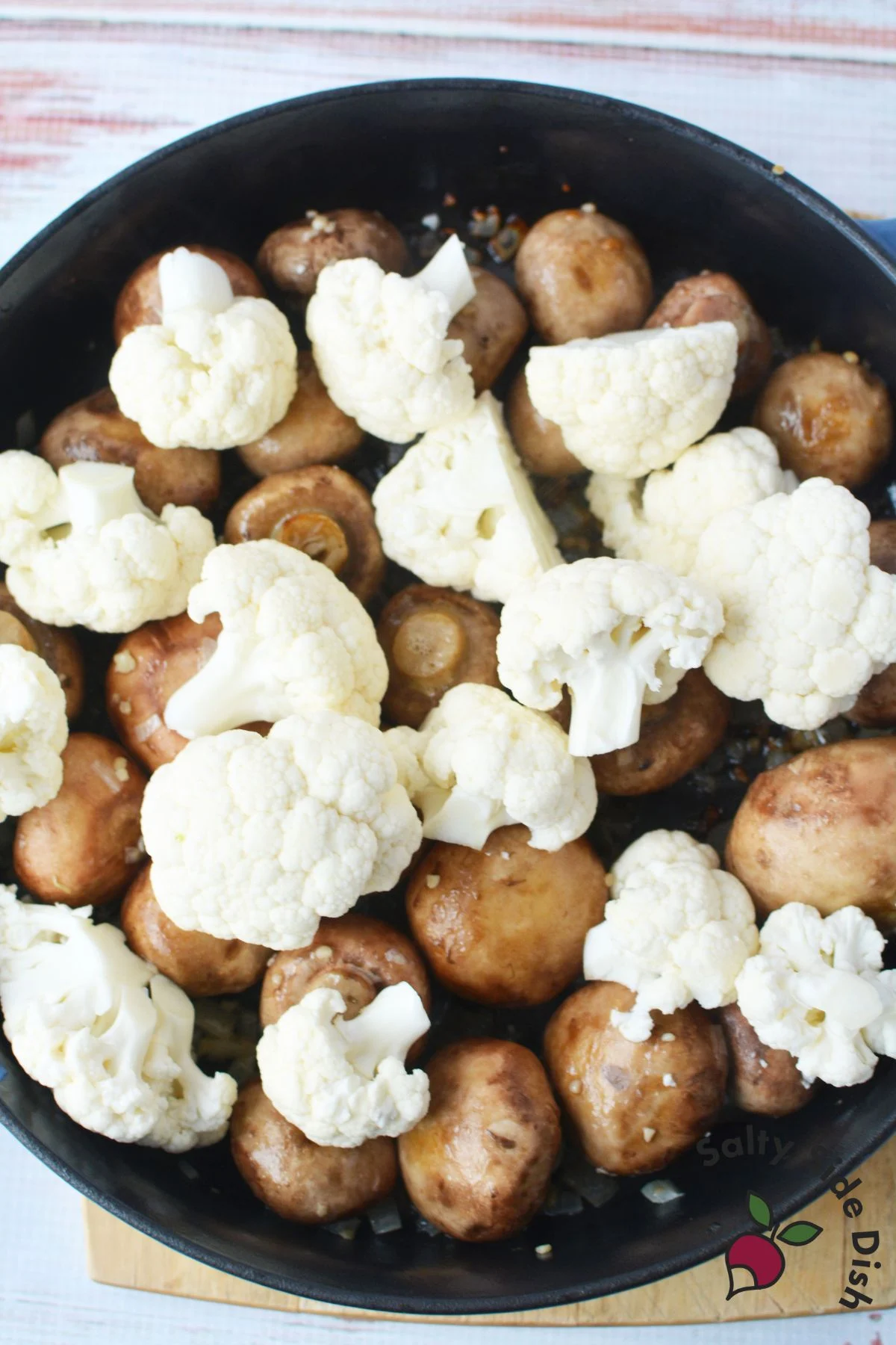 adding raw cauliflower to skillet.