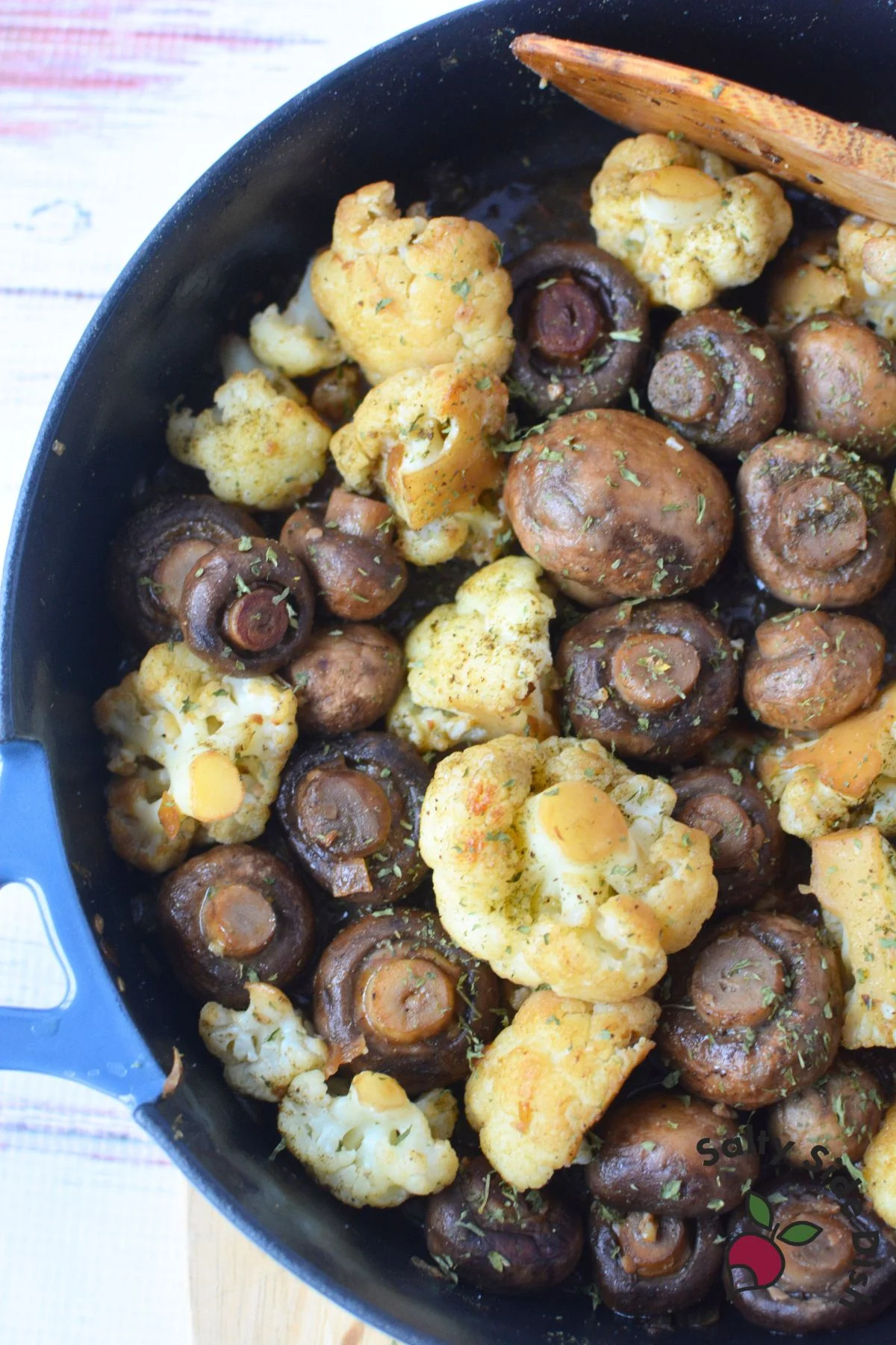 adding broth to cooking mushrooms and cauliflower florets.