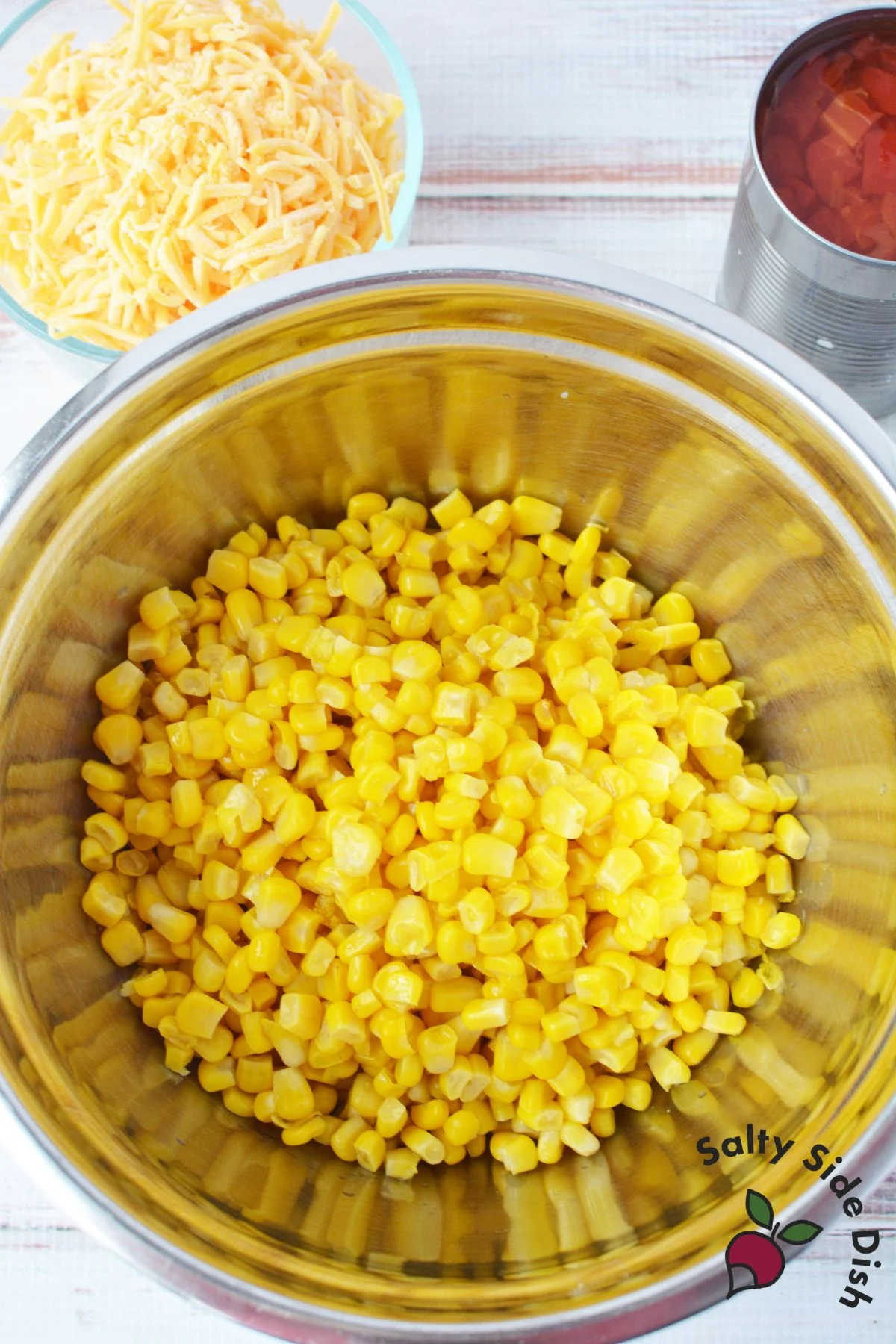 corn in a bowl with cheese and rotel on the side.
