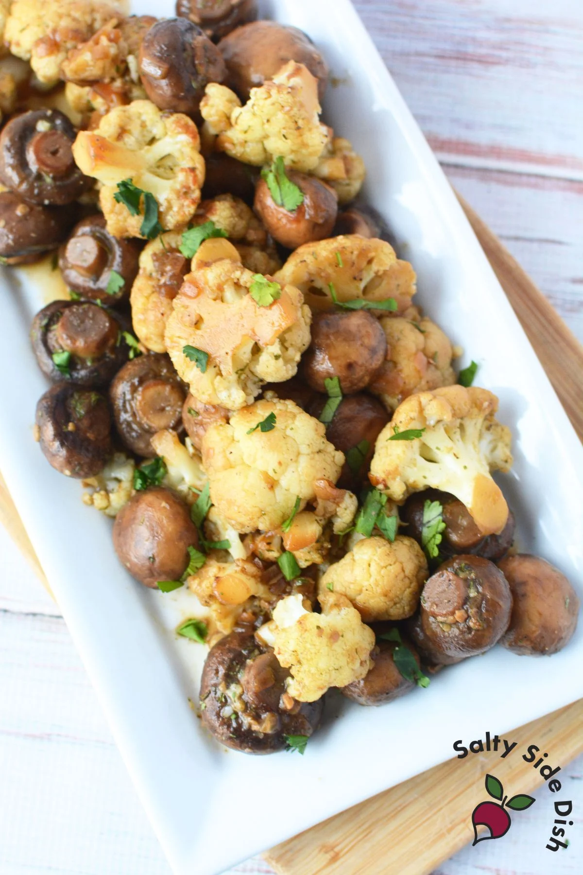 white plate of cooked cauliflower and mushrooms.