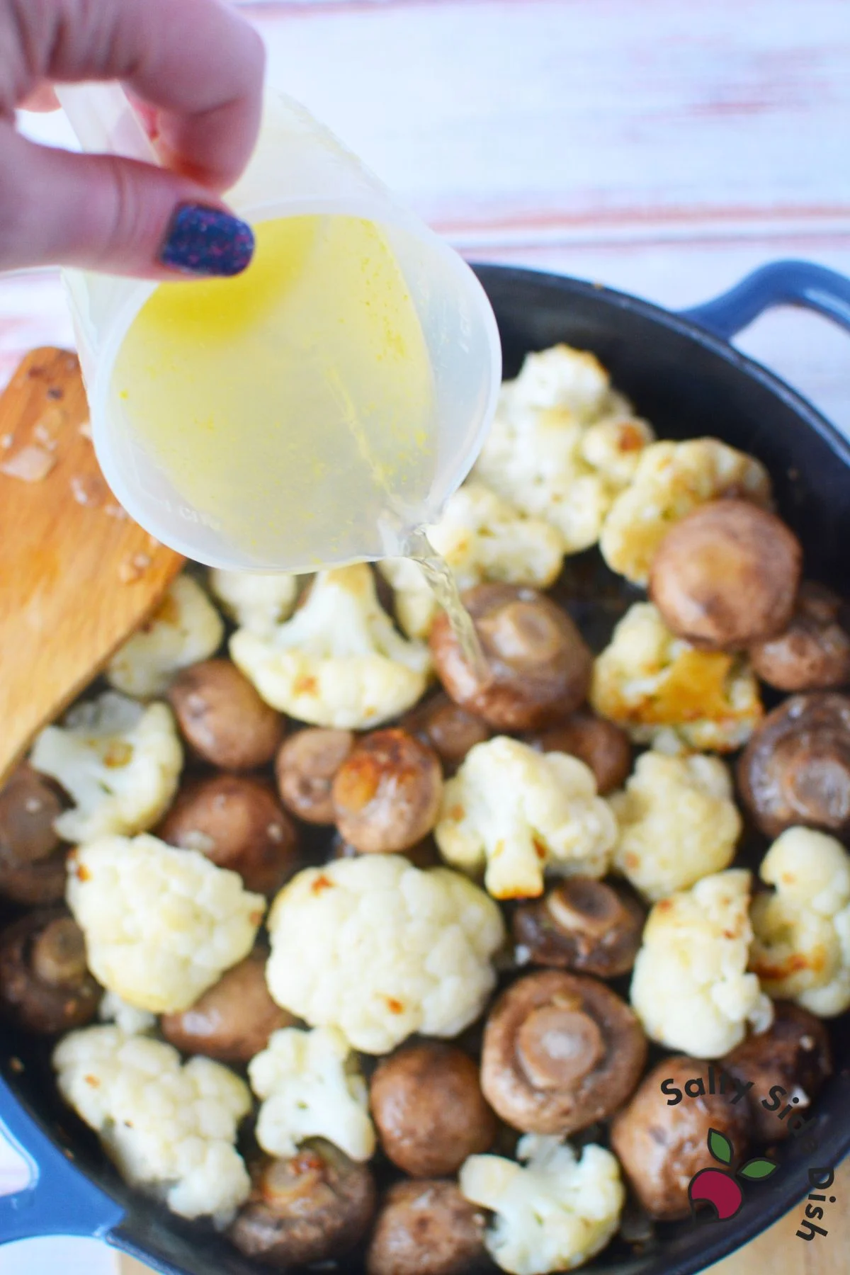 pouring broth into skillet.