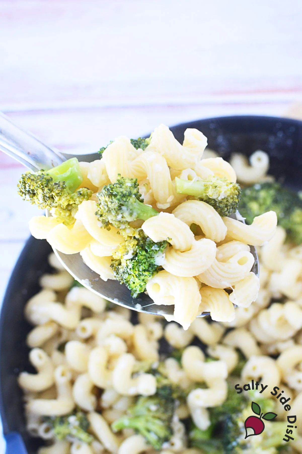 serving pasta and broccoli for a side dish while in a spoon.