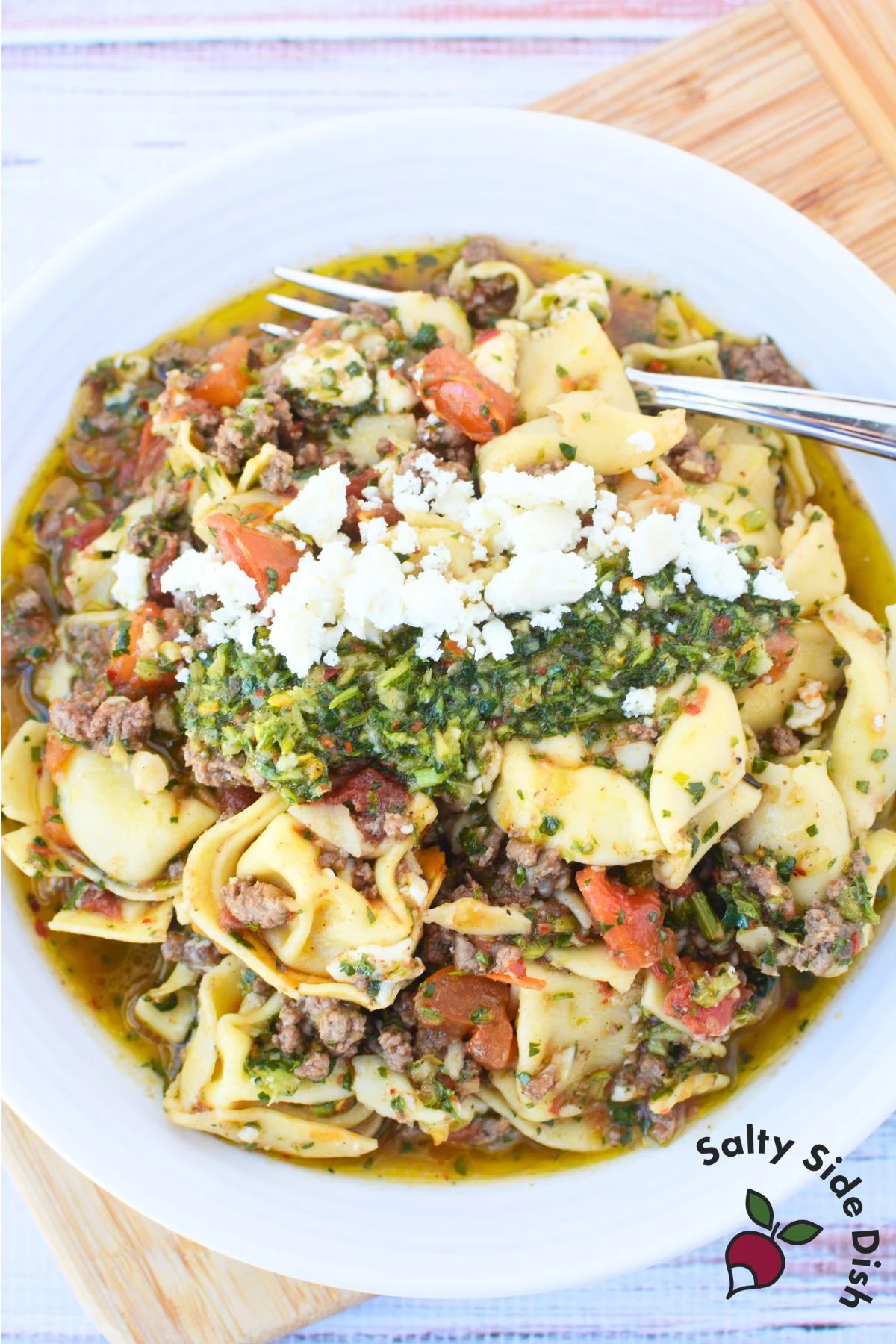large bowl of chimichurri tortellini with cheese on top.