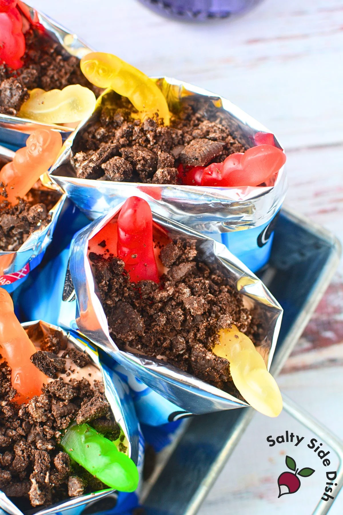 Zoomed-in view of dirt dessert cup filled with pudding, Oreo crumbs, and gummy worms.