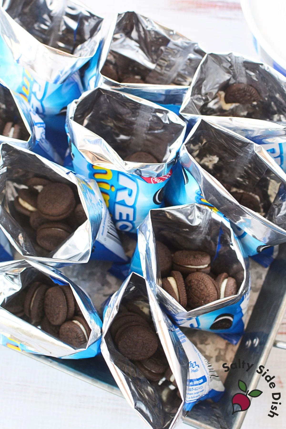 Opened mini Oreo snack bags arranged upright on a tray, prepped for dirt dessert filling.