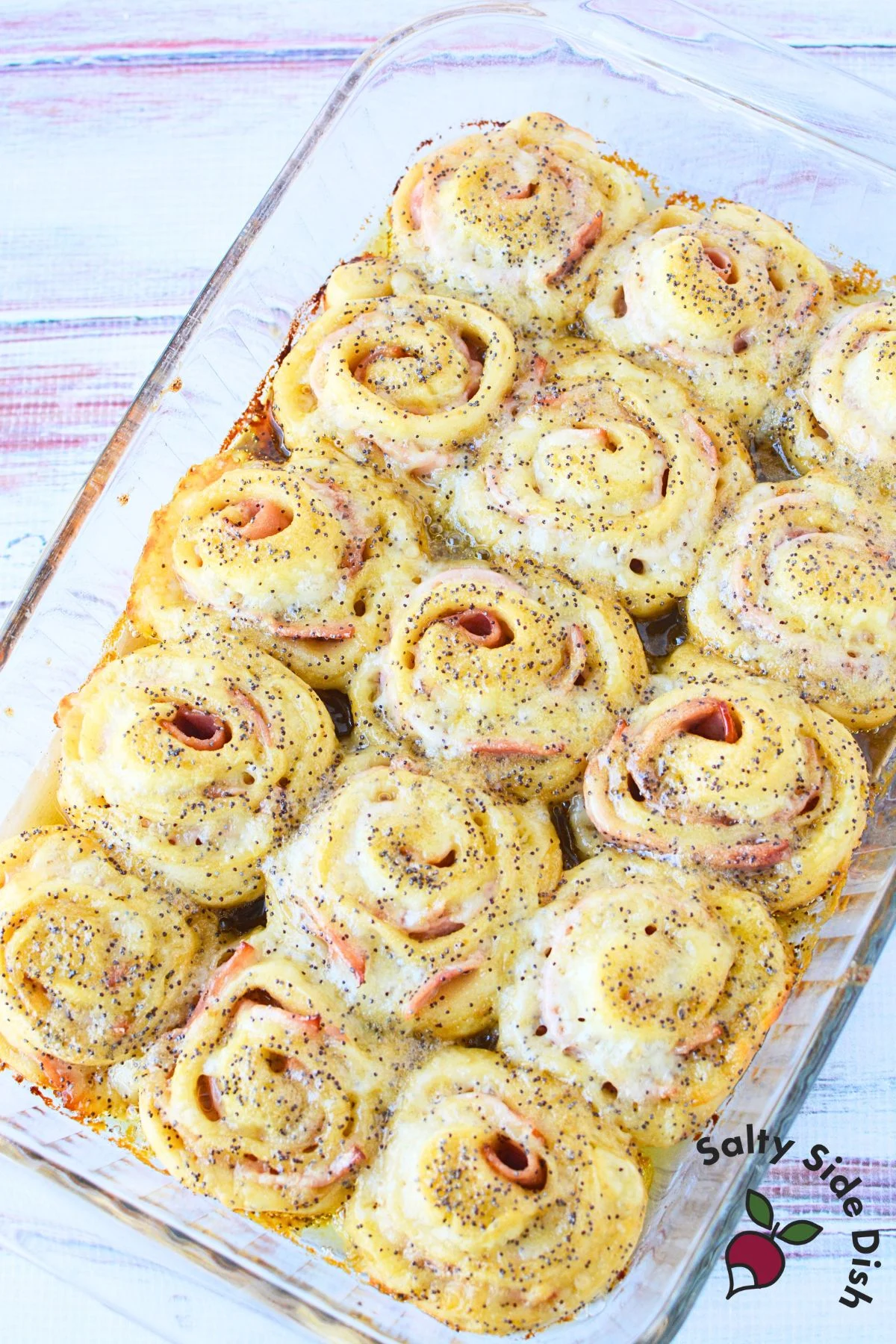Top-down view of ham and cheese pinwheels baked with brown sugar mustard glaze and sprinkled with poppy seeds
