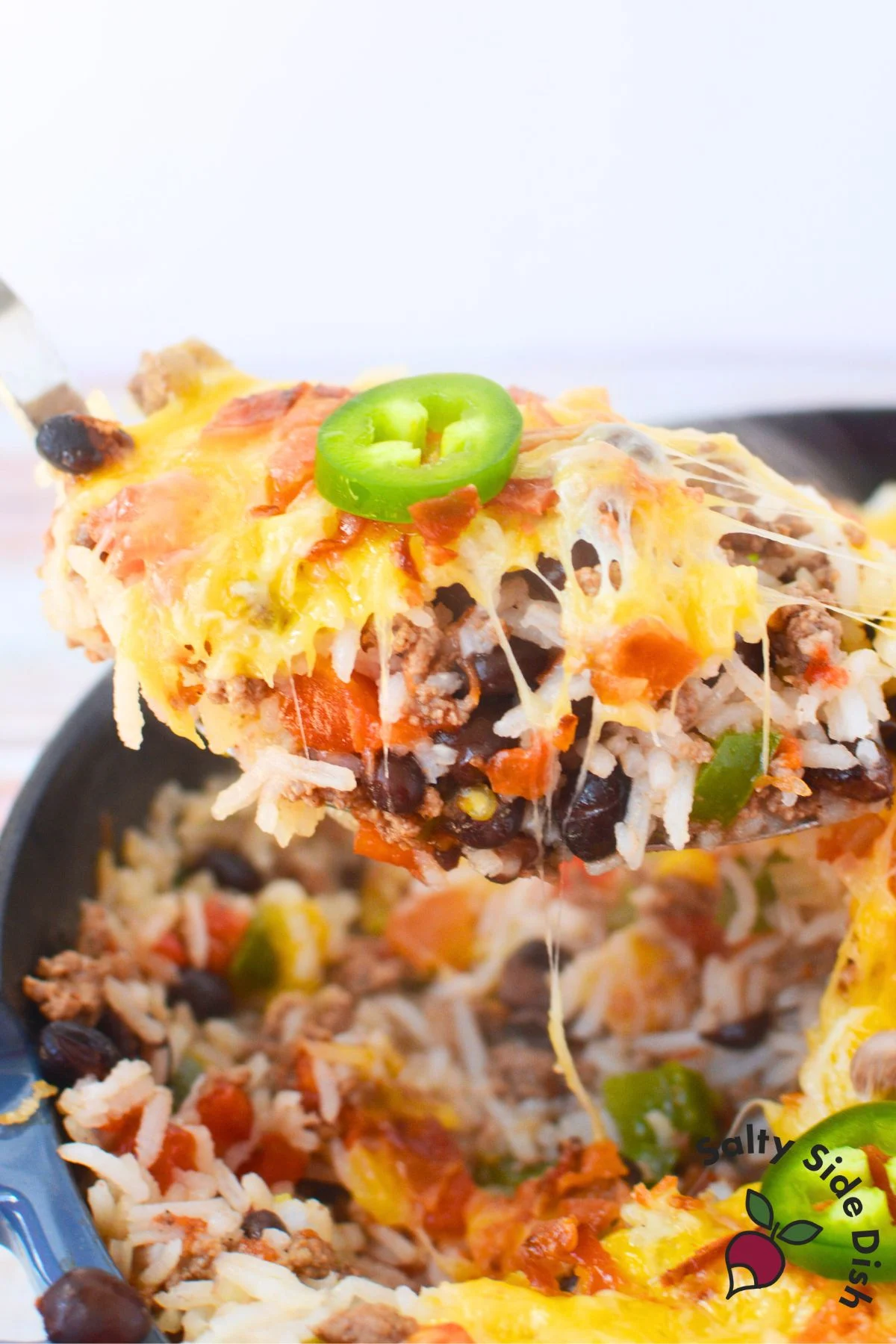 serving a huge spoonful of texas rice with ground beef, rice, rotel, and cheese.