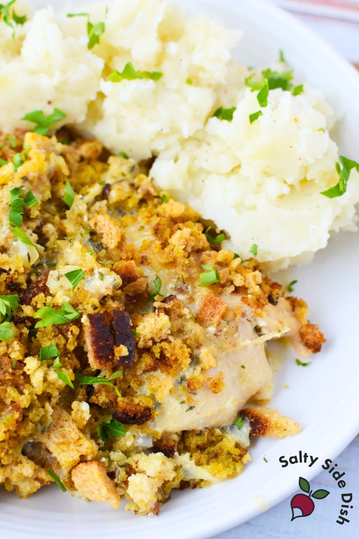 Closeup of crockpot chicken and dressing topped with golden stuffing and fresh parsley