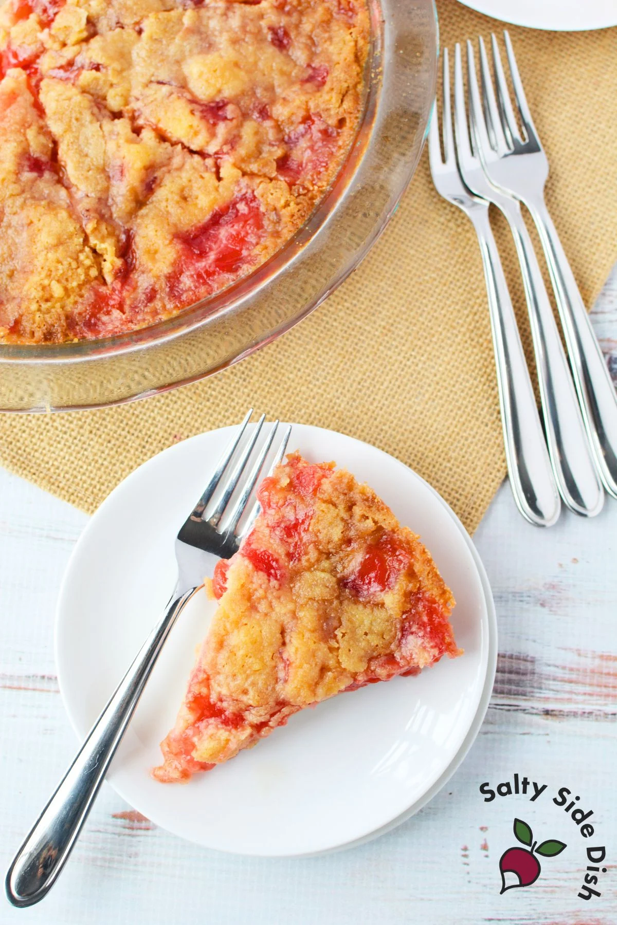 Overhead image of golden-baked cherry impossible pie in a glass pie plate with visible cherry pieces.
