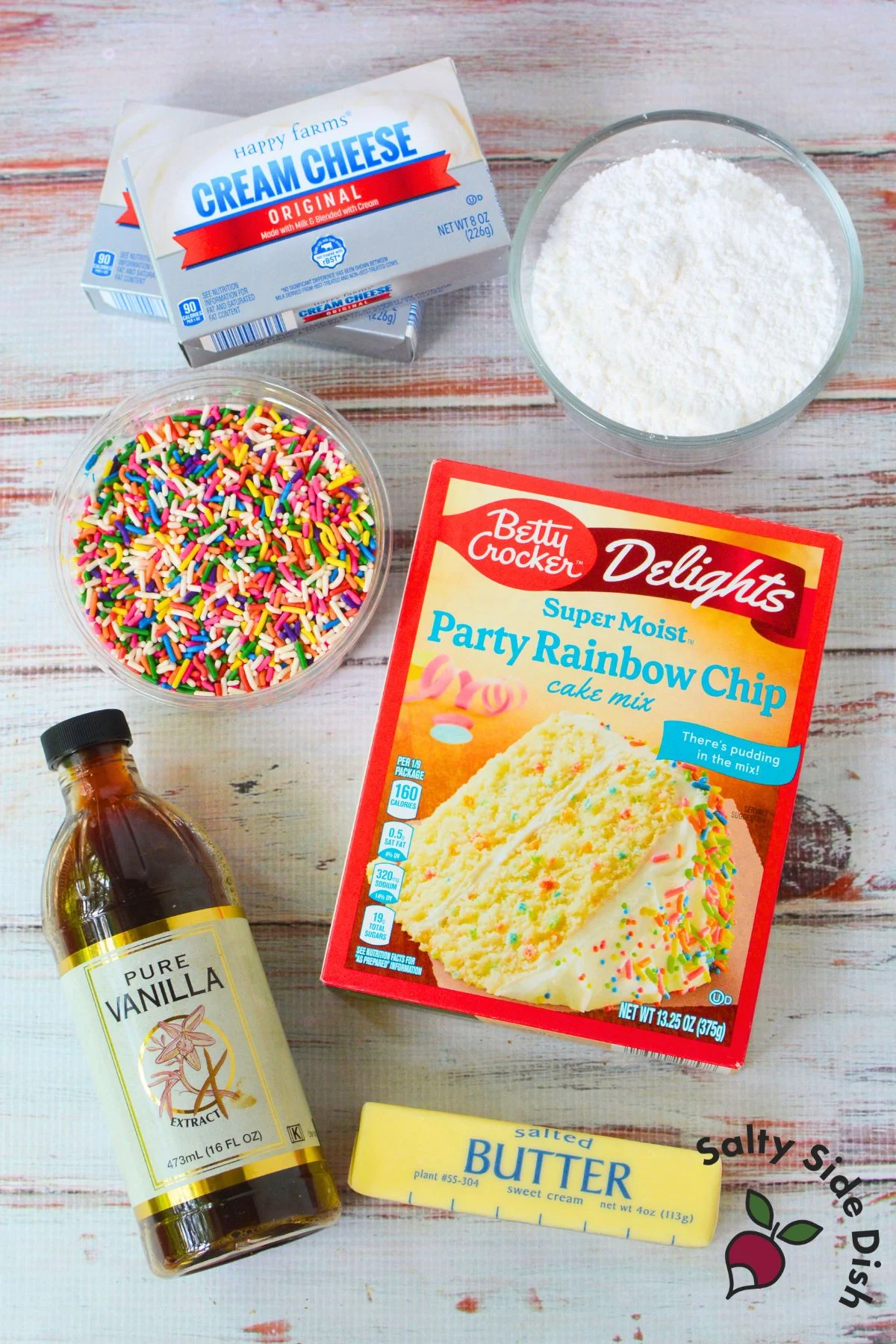 Ingredients for birthday cake cheese ball including cream cheese, butter, funfetti cake mix, powdered sugar, vanilla extract, and rainbow sprinkles.