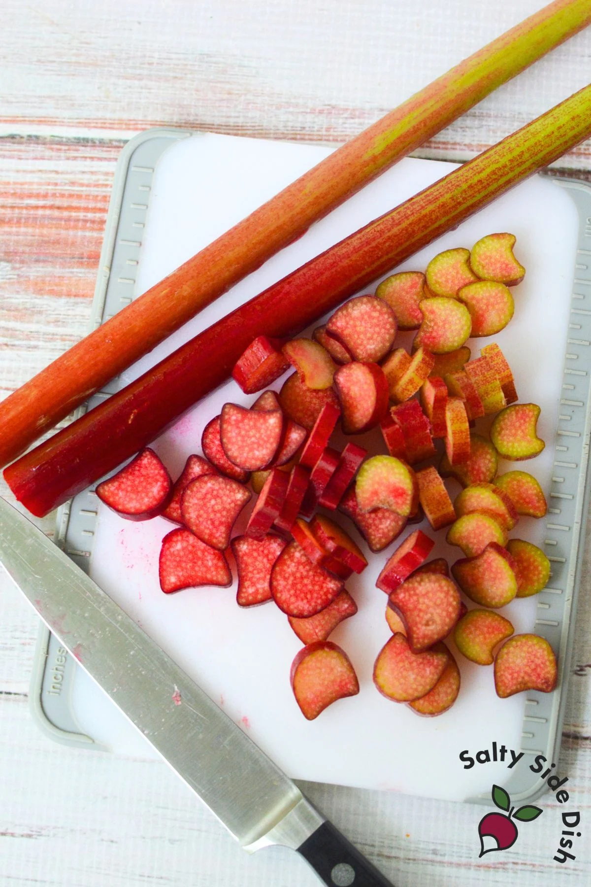 Freshly chopped rhubarb on a cutting board, ready to be used in a homemade rhubarb crisp recipe.