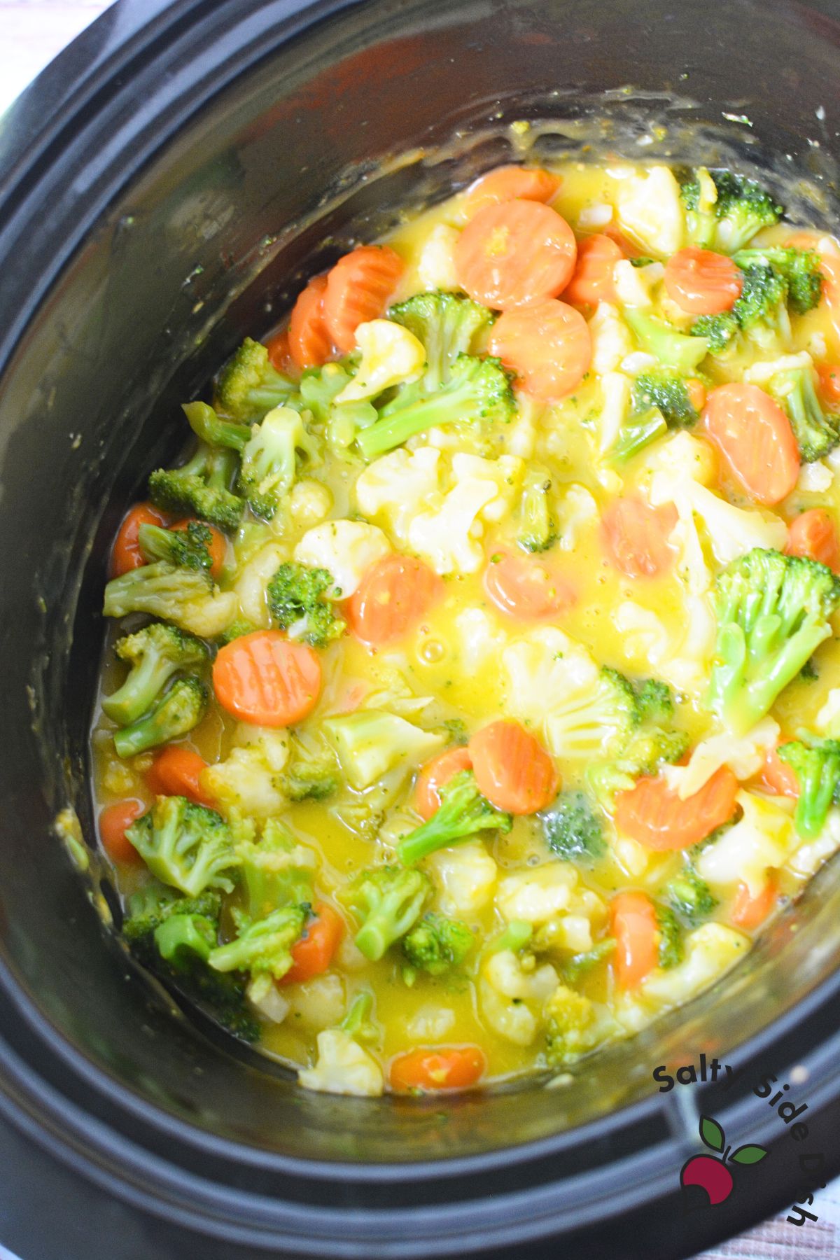 Slow cooker cheesy vegetables with melted cheese on top
