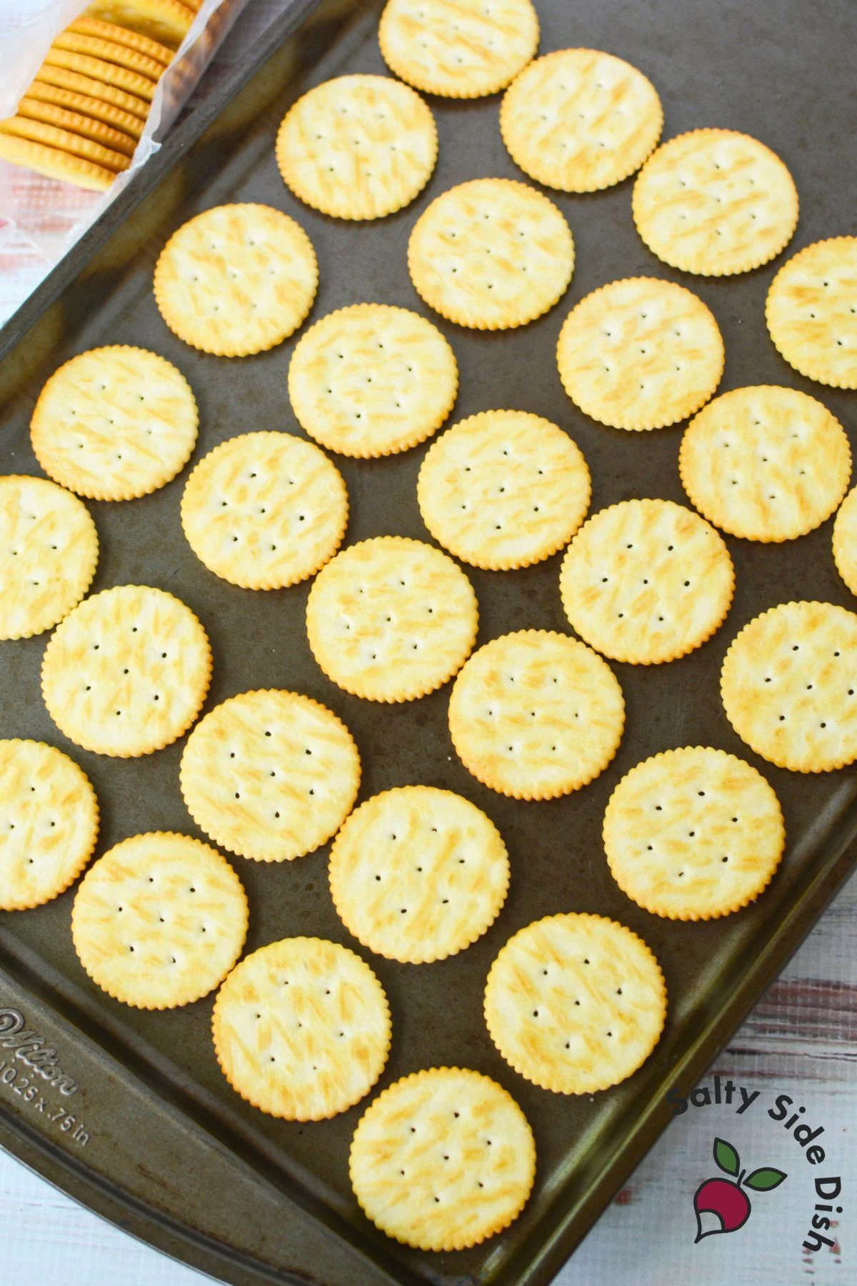 Hand pressing second Ritz cracker over melted Rolo candy to make sandwich cookie