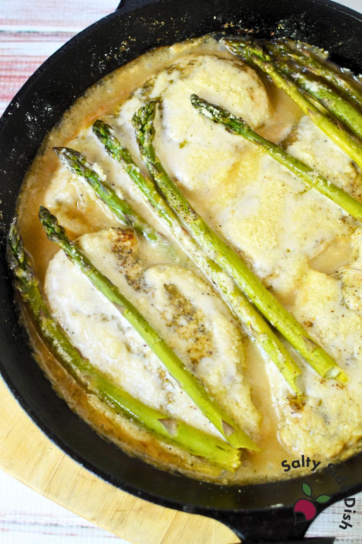 Chicken breasts in a cast iron skillet covered in creamy Girard’s Caesar dressing
